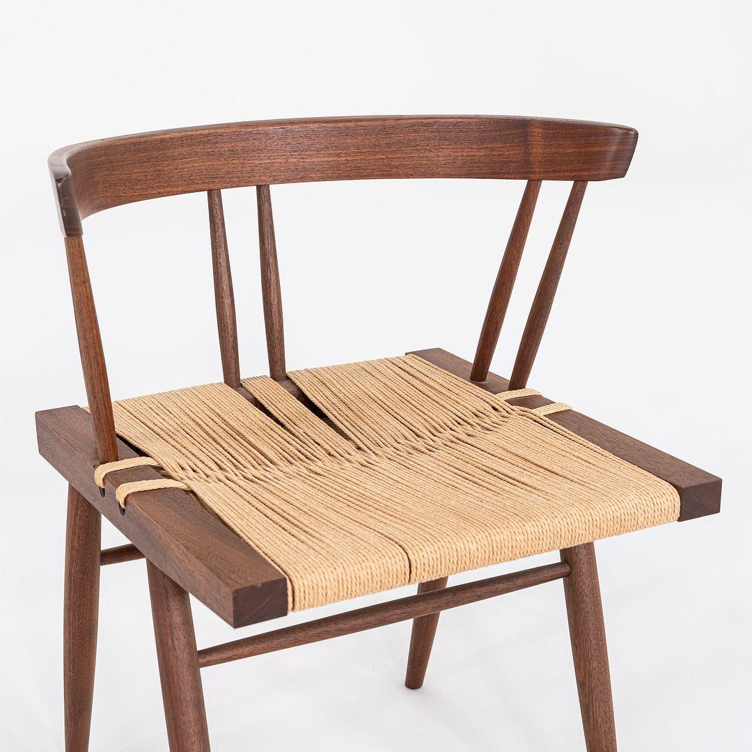 This is a set of six Grass Seated Dining Chairs, originally designed by George Nakashima in the 1940s. These particular examples are signed by Mira Nakashima and dated with 2014 as production year. They are comprised of a black walnut frame with a