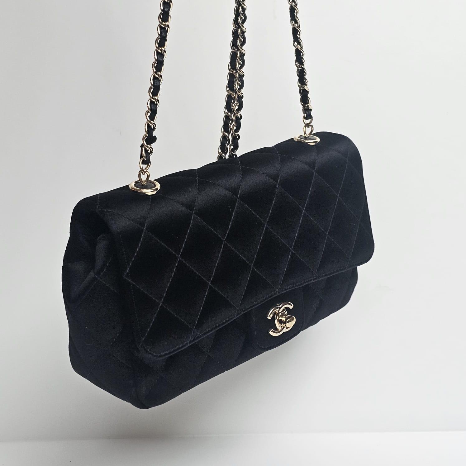 Chanel mini satin rectangle flap bag in black with light gold hardware. In very good condition with no significant signs of wear. Series 21. Comes with its hologram and card. 