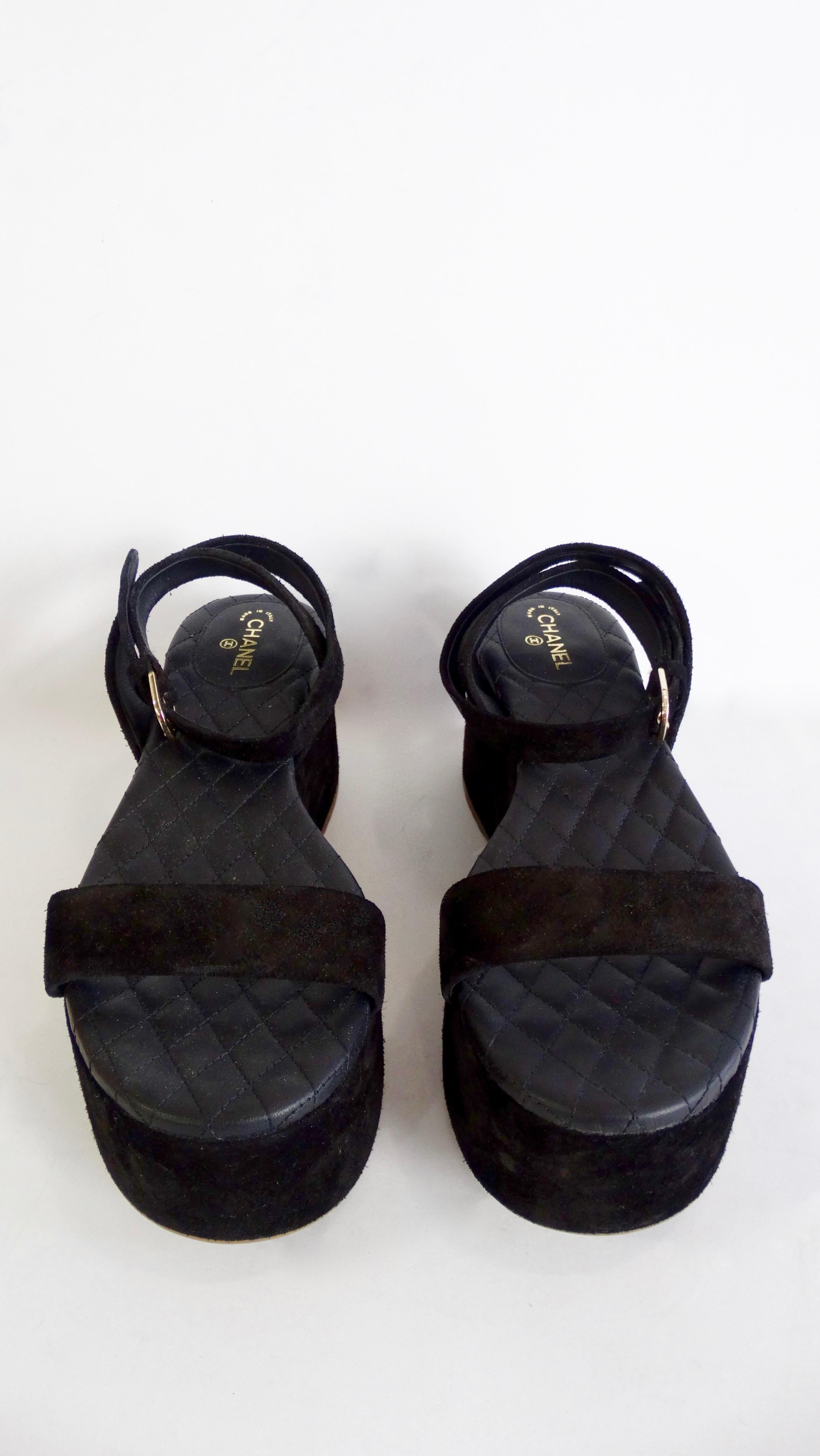 Take a walk with Chanel! Circa 2015, these platform sandals are made of black suede and feature the signature Chanel quilting on the insole. Includes a silver plated CC logo at the heel and a wrap ankle strap with a 