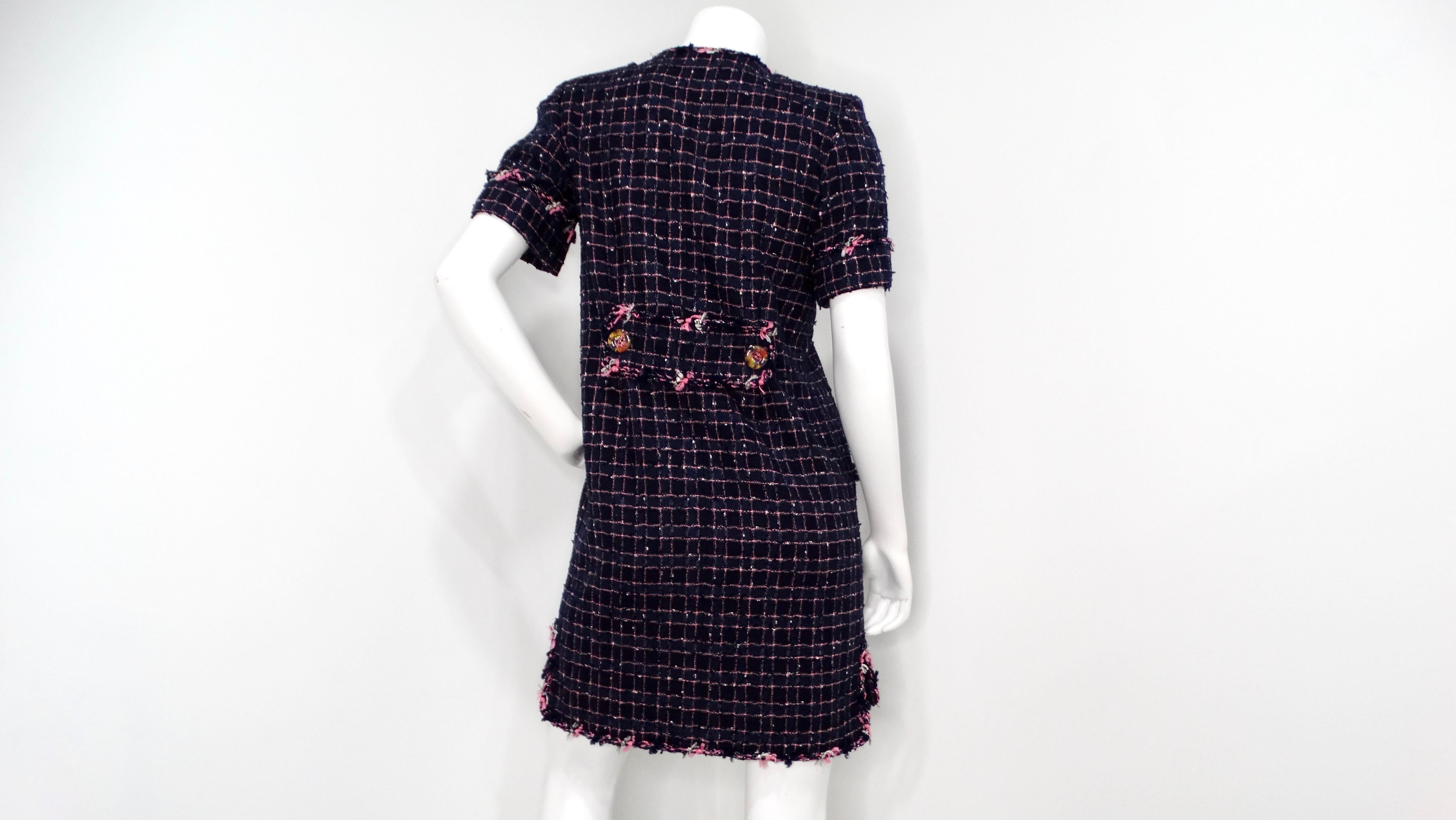 The 2015 Chanel Fantasy Blue & Pink Tweed Button-Up Mini Dress embodies classic elegance with a modern twist. The dress features a striking navy blue base accented by a playful mix of white and pink detailing, characteristic of Chanel's signature