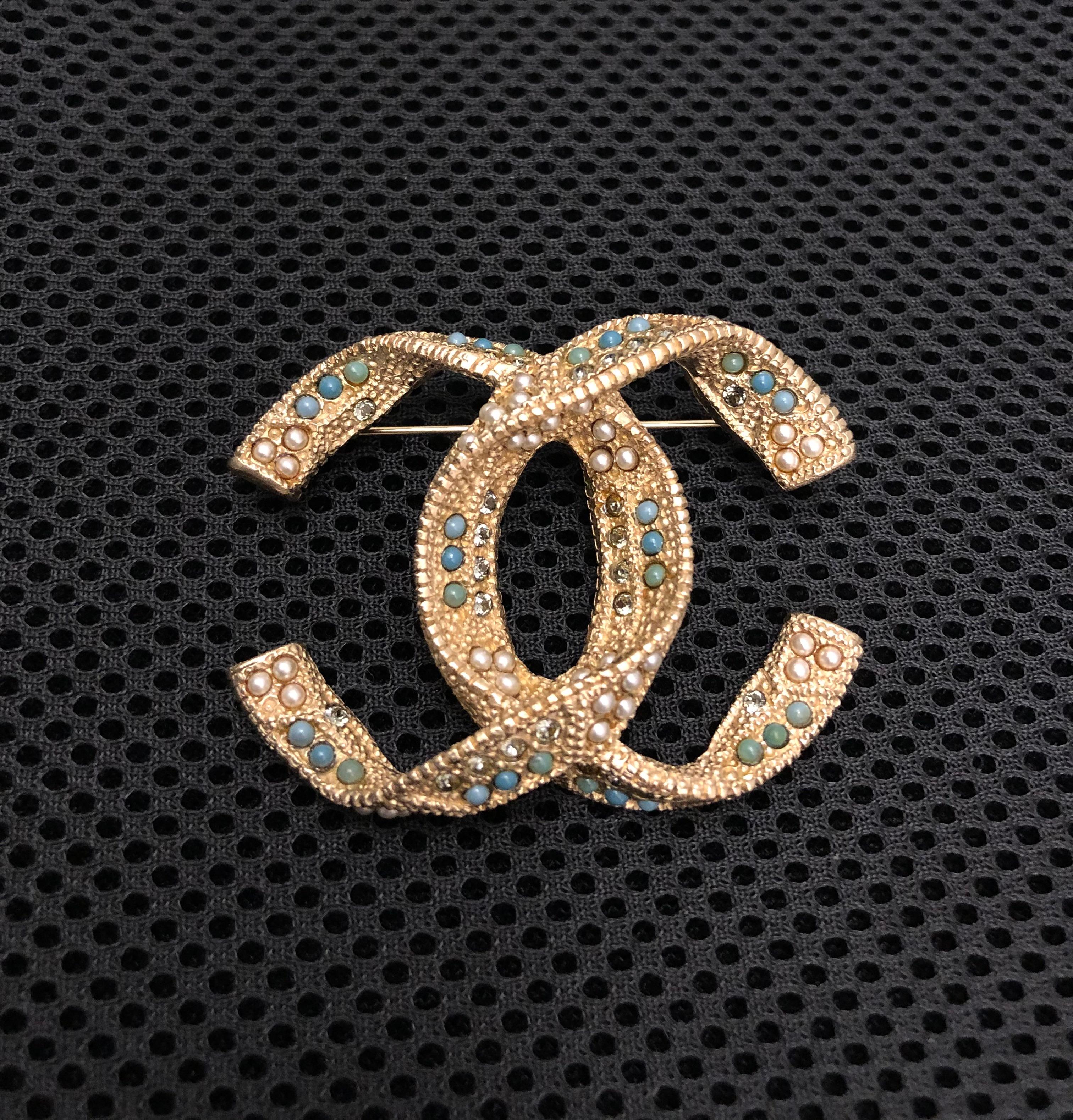 This CHANEL CC brooch is crafted of gold toned metal encrusted with colored faux pearls and rhinestones. Stamped A15 K made in France. Measures approximately 5.6 x 4.2 cm. Comes with box.

Condition: Like new and in excellent condition. Minimal to