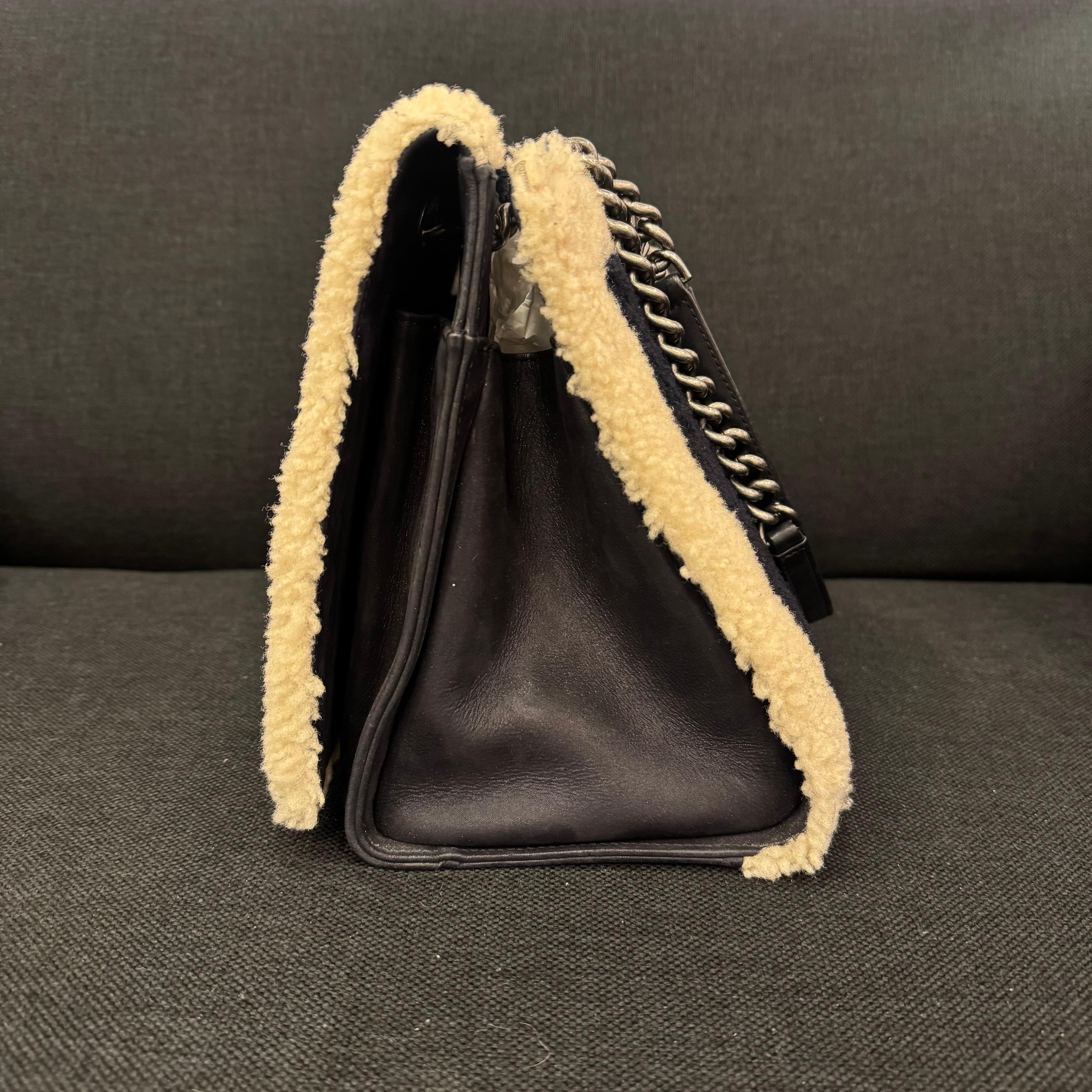 Chanel shearling shopping tote bag in black and off white. Cute little tote bag. Can be worn shoulder. The shearling is slightly dirty but overall still in good condition. The white trimming is not as yellow as the picture, only due to yellow