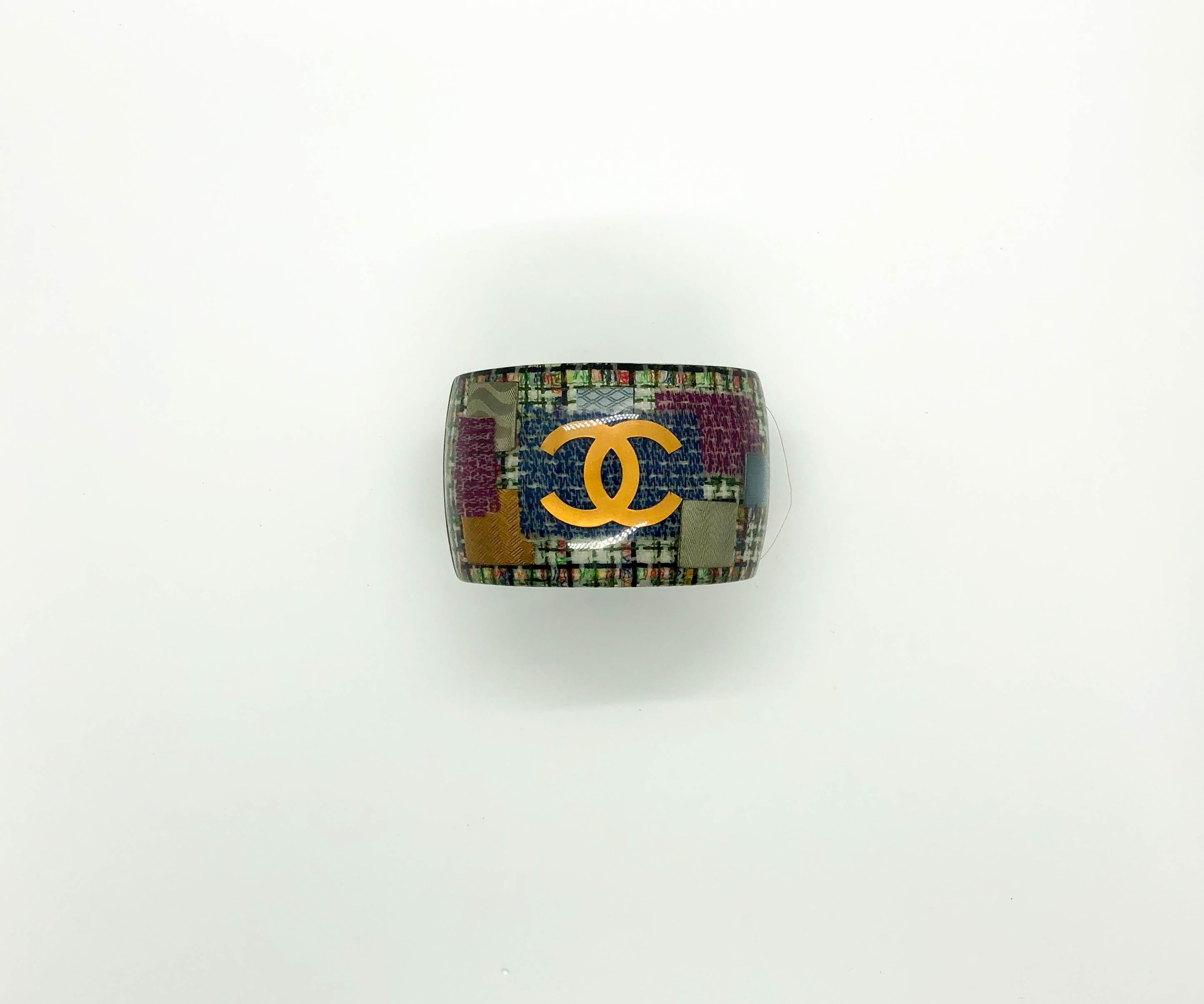 Chanel Tweed and Logo Resin Cuff Bracelet. This striking piece by Chanel was crafted for the 2015 Spring Summer Collection. The SS15 collection was all about women’s rights and empowerment. The models on the runway staged a demonstration at the end