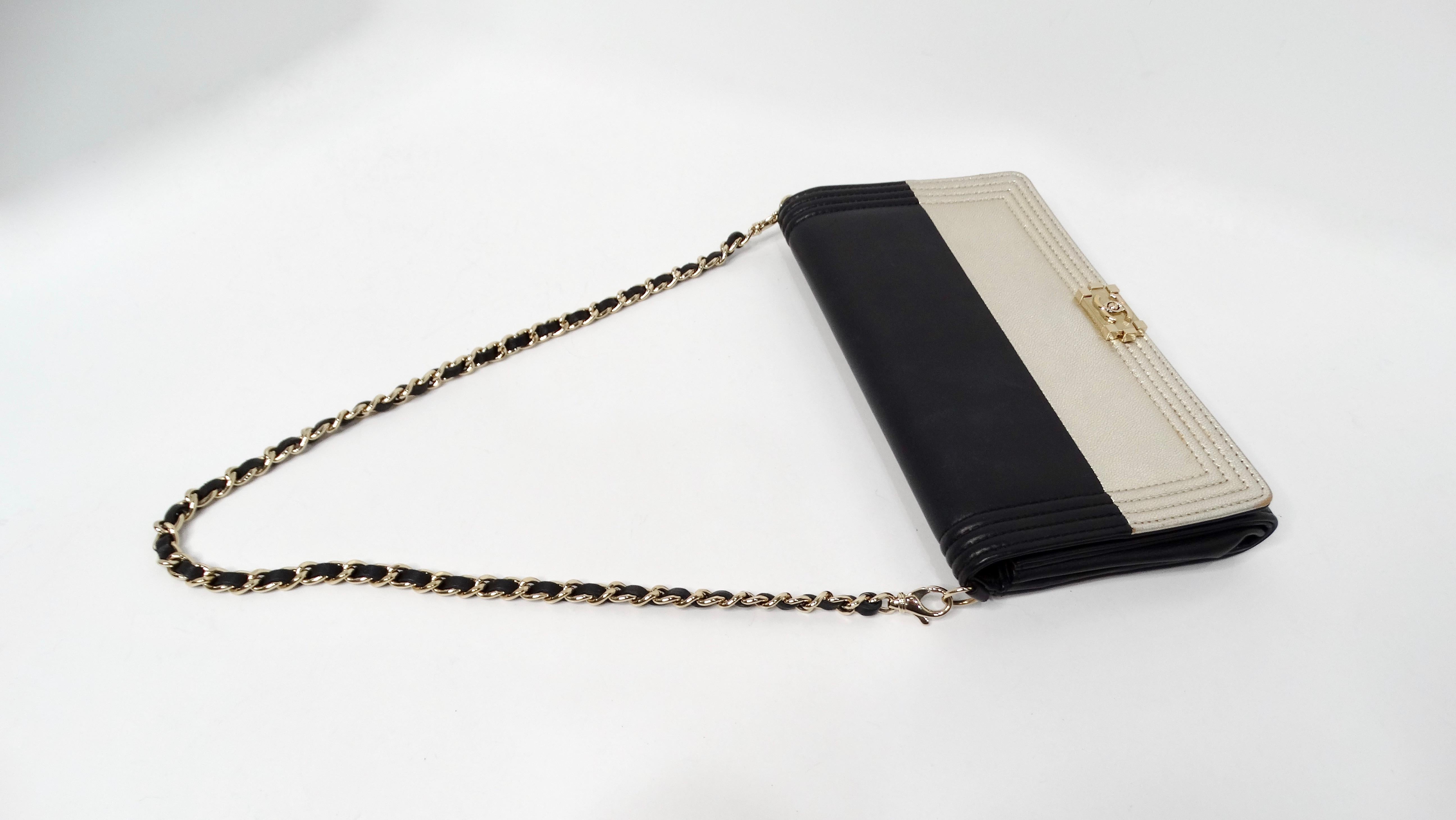 Peppen Sie Ihr Accessoire auf mit der exquisiten Chanel Two-Toned Metallic Lambskin Boy Clutch mit Kette von 2015. Dieses atemberaubende Stück verkörpert das berühmte Boy-Design mit einem auffälligen Kontrast aus luxuriösem schwarzem Lammfell auf