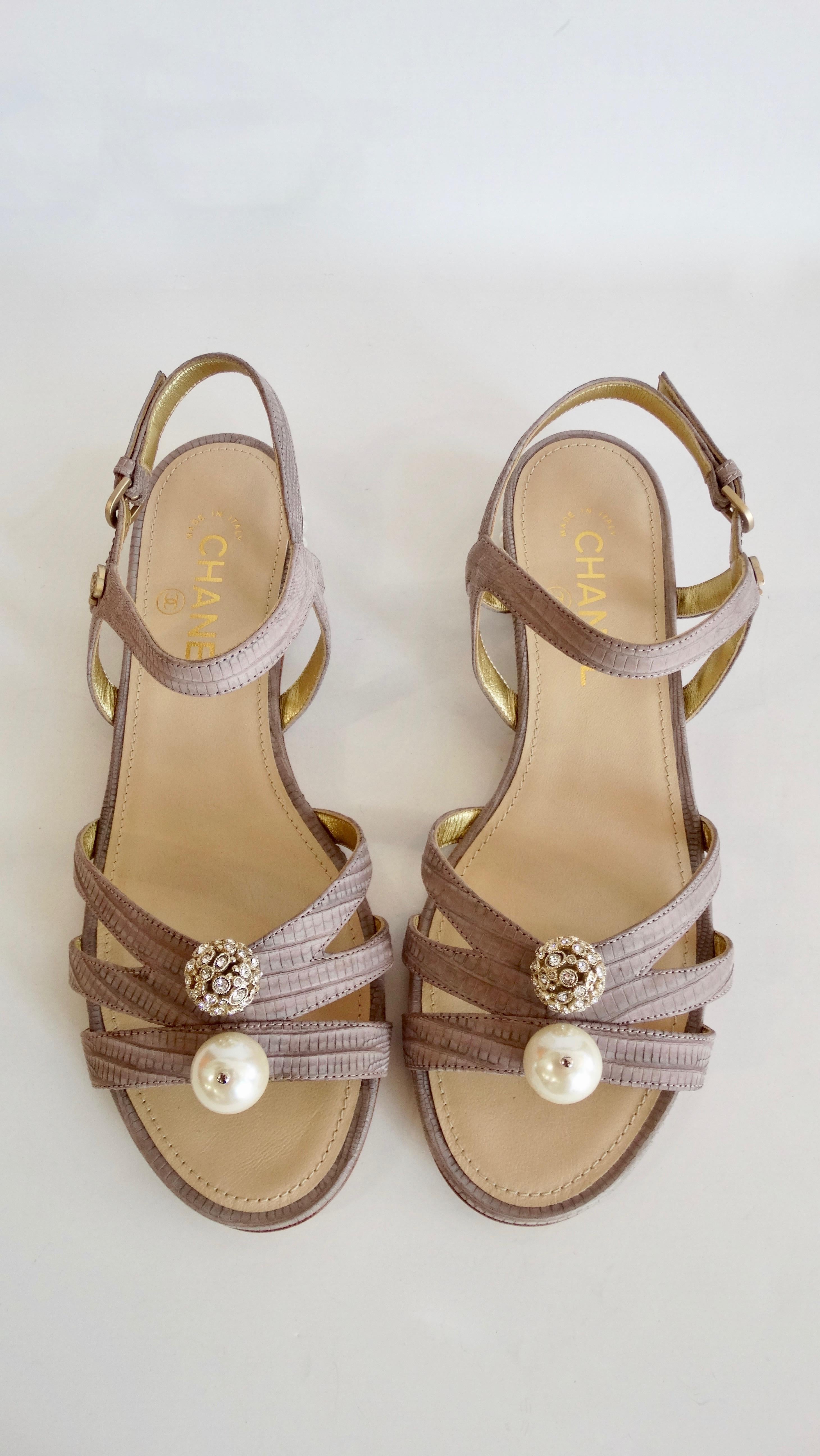 Complete your shoe collection with these chic Chanel sandals! Circa 2015 from their Cruise collection, these strappy sandals are crafted from pastel purple dyed lizard skin and feature a faux pearl studded heel. Front of sandal is adorned with a