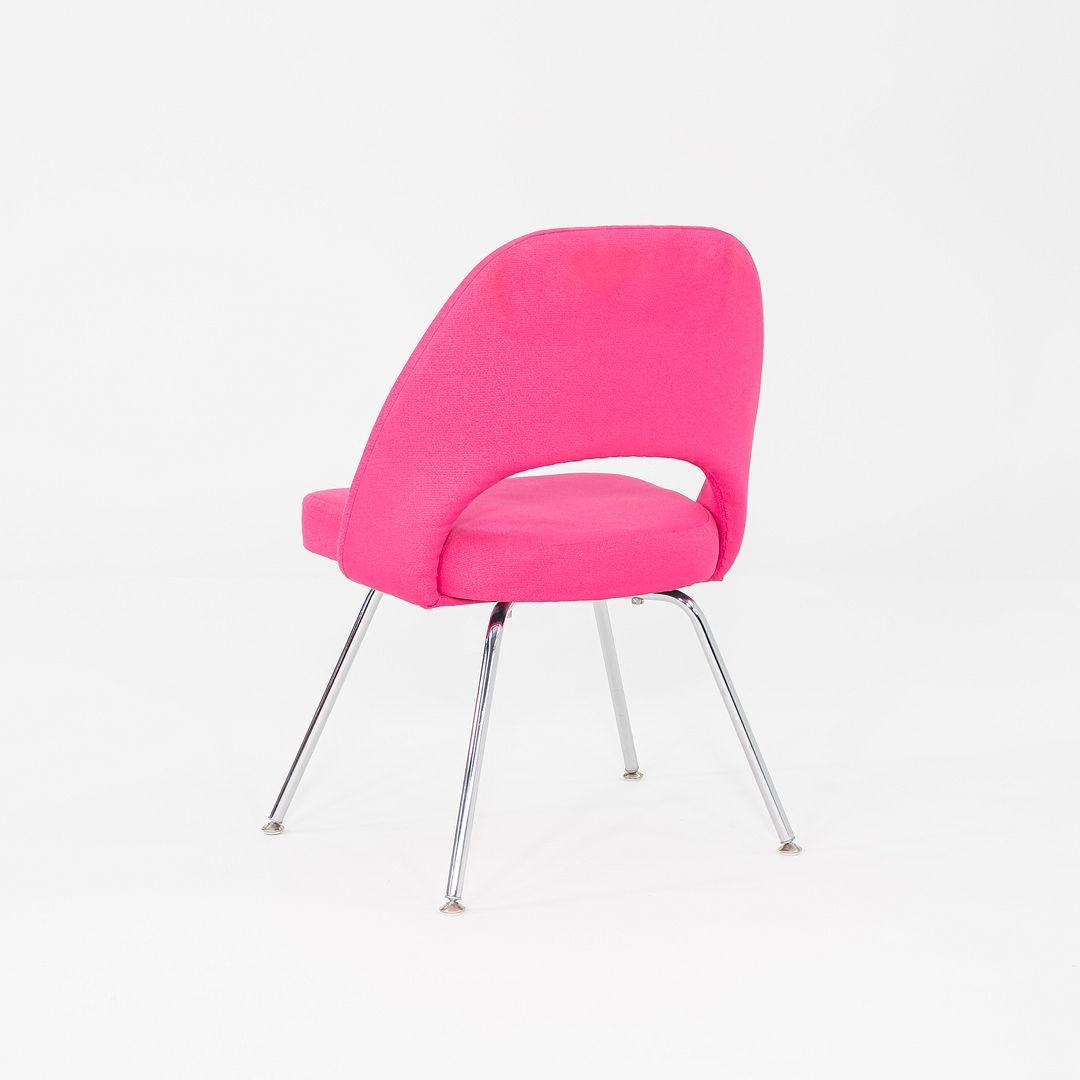 This is a Saarinen Executive Side Chair, originally designed by Eero Saarinen in 1957. These particular examples were produced by Knoll in the USA in 2015. The chairs feature upholstered seats in pink fabric, and the legs are formed of chromed