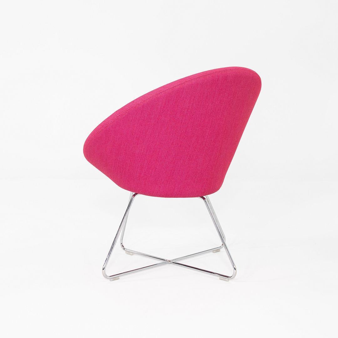 This is a Conic Lounge Chair, originally designed by PearsonLloyd for Allermuir. These examples were produced in the UK in 2015. They are comprised of a polished chrome base and molded foam seats that are upholstered in pink fabric, 653 Steelcut
