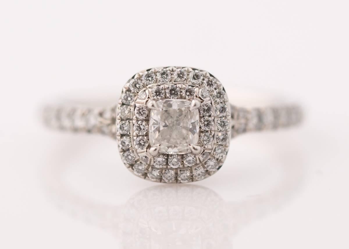 2015 Bague de fiançailles Tiffany Soleste - Platine et diamants

La pierre centrale, de taille coussin, est entourée d'un double halo de diamants brillants. 
Des diamants brillants partent du halo pour couvrir les épaules fendues et s'étendent