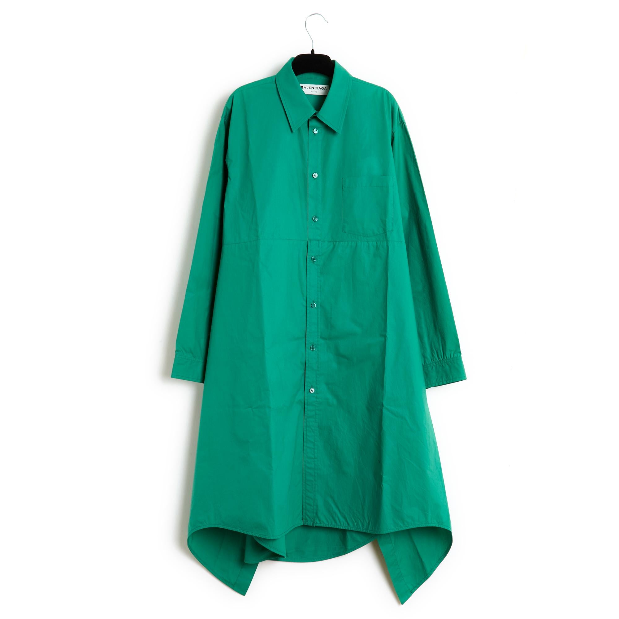Balenciaga dress from 2016 in green cotton cloth, oversized volume, flared cut, shirt collar, buttoned all the way in front, overskirt in the same fabric, closed in front with the same series of buttons and closed, or not, at the back with a button,
