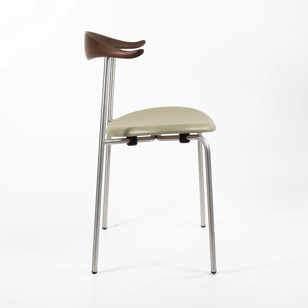 Listed for sale is a CH88P dining chair, made with a stainless steel frame, smoked oil oak back, and leather seat. The chair, designed by Hans Wegner and produced by Carl Hansen & Son in Denmark, dates to 2016 and is guaranteed as authentic.