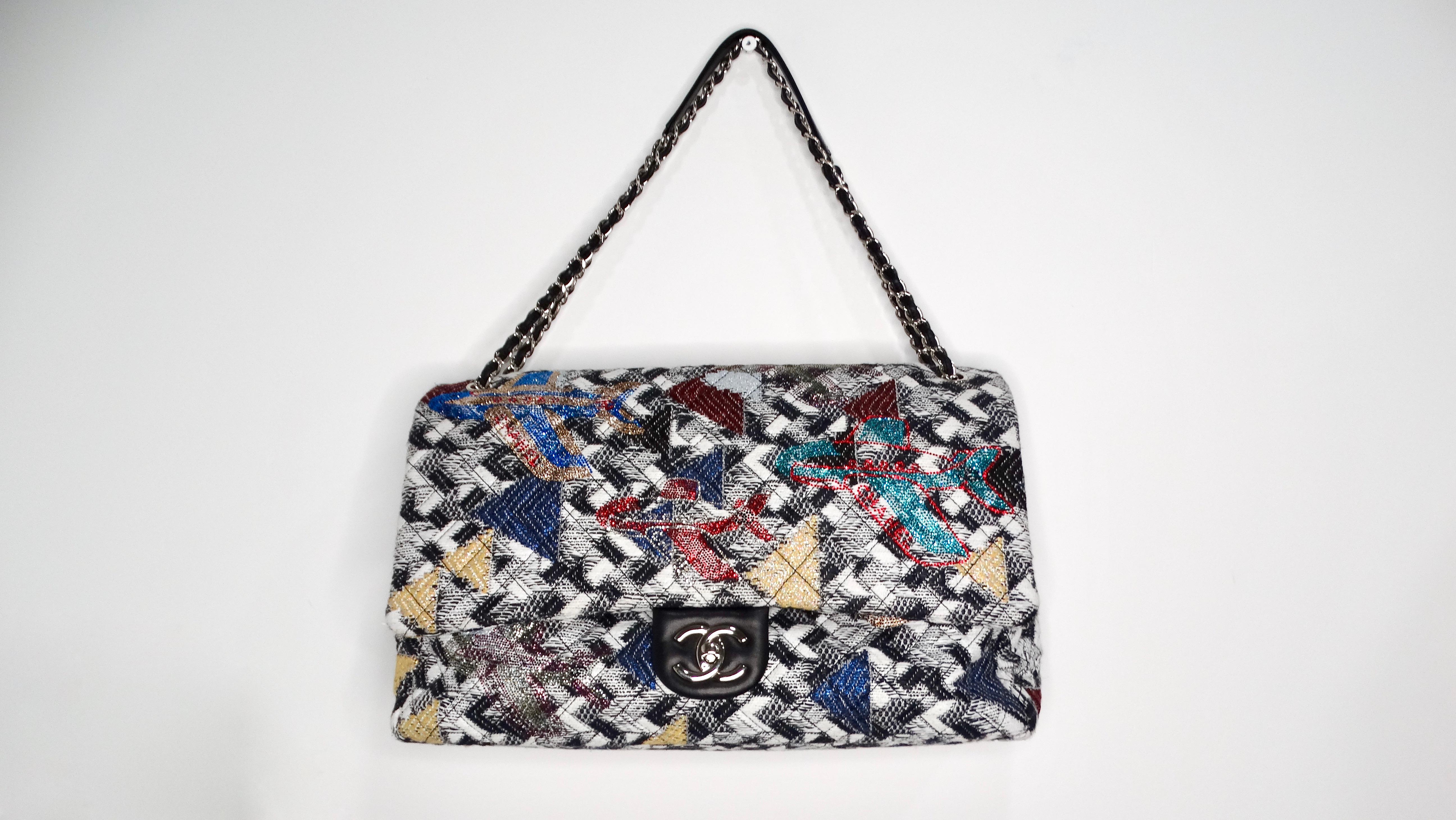 The 2016 Chanel Airlines Tweed Strass Rhinestone XXL Flap Bag is an exquisite statement piece that embodies the luxurious spirit of the Chanel brand. Its black and white tweed base is embellished with vibrant rhinestone airplane motifs, capturing a