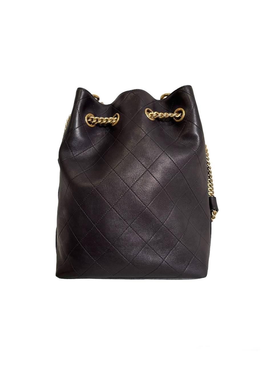 Chanel signed bucket bag, made of black quilted leather and golden hardware. Equipped with an internal magnetic button closure. Equipped with a chain handle and an adjustable sliding shoulder strap made of leather and large chain link, with 