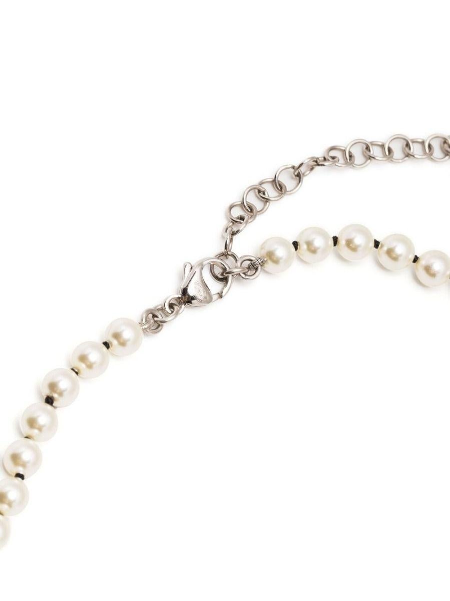 Chanel double-strand faux pearl necklace with bow and CC logo stations, from Spring/Summer 2016. This classic Chanel necklace features a double strand of faux pearls with crystals and pearl-embellished bows in Chanel's signature champagne gold tone
