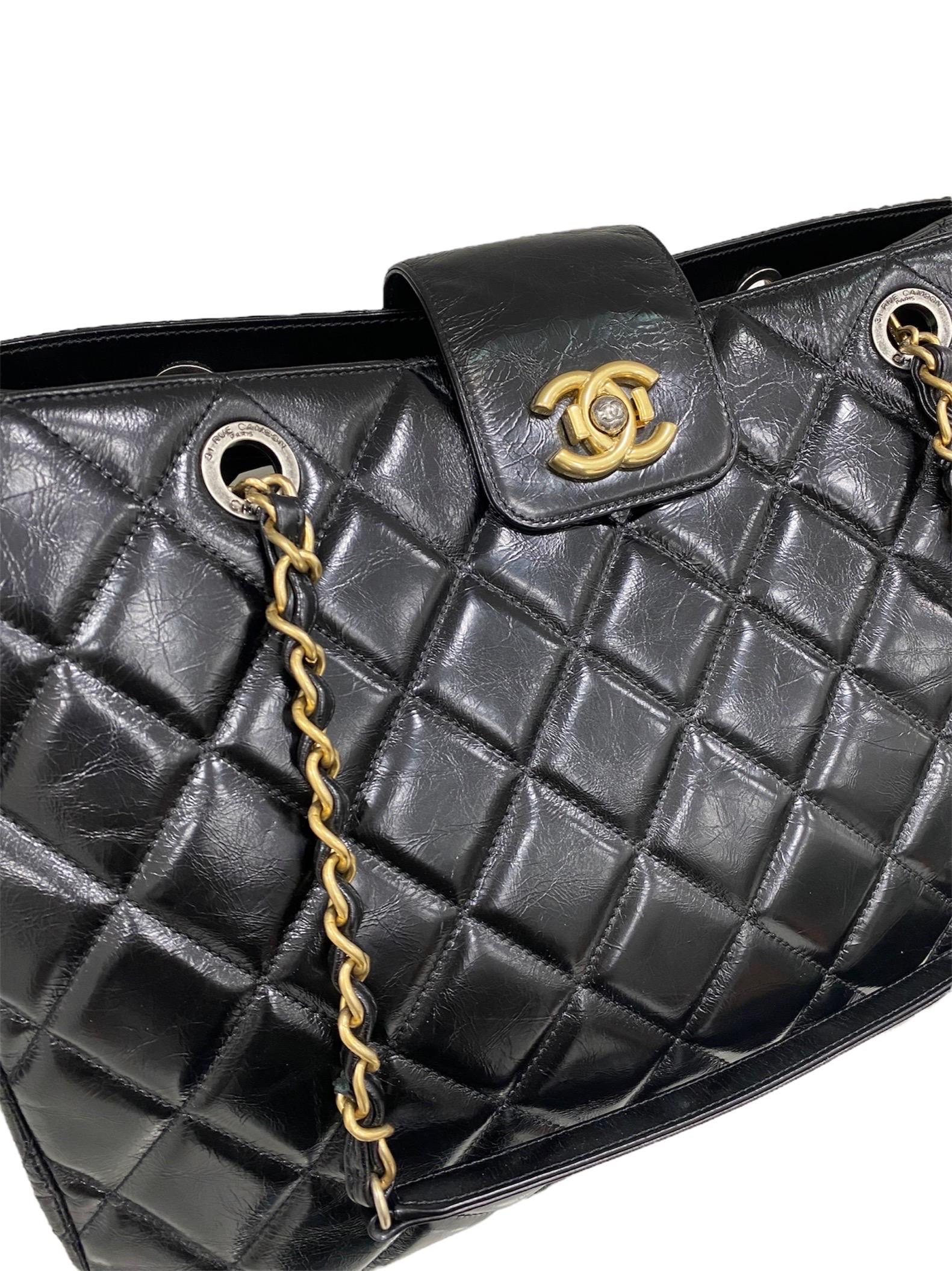 Shopper bag by Chanel, year 2015 – 2016, in shiny black quilted leather with golden hardware.
It has a closure with band and interlocking button CC. The interior is lined with a soft burgundy fabric and is divided into 2 compartments with a central