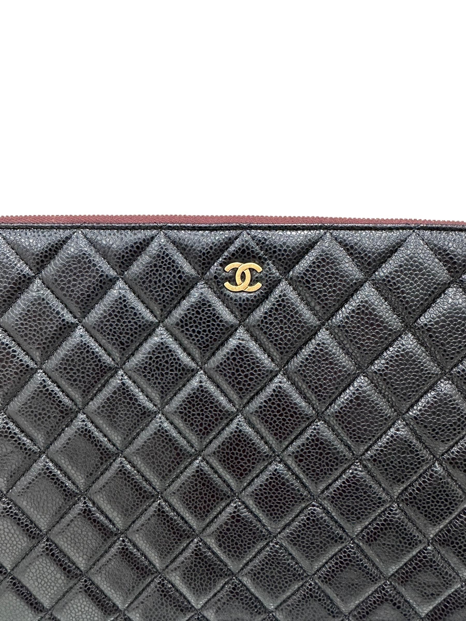 Clutch signed Chanel, Timeless model, made of black grained leather with golden hardware. Equipped with a top closure with zip, internally lined in burgundy quilted fabric, roomy for the essentials. It has no handle. Year of production 2015/16. It