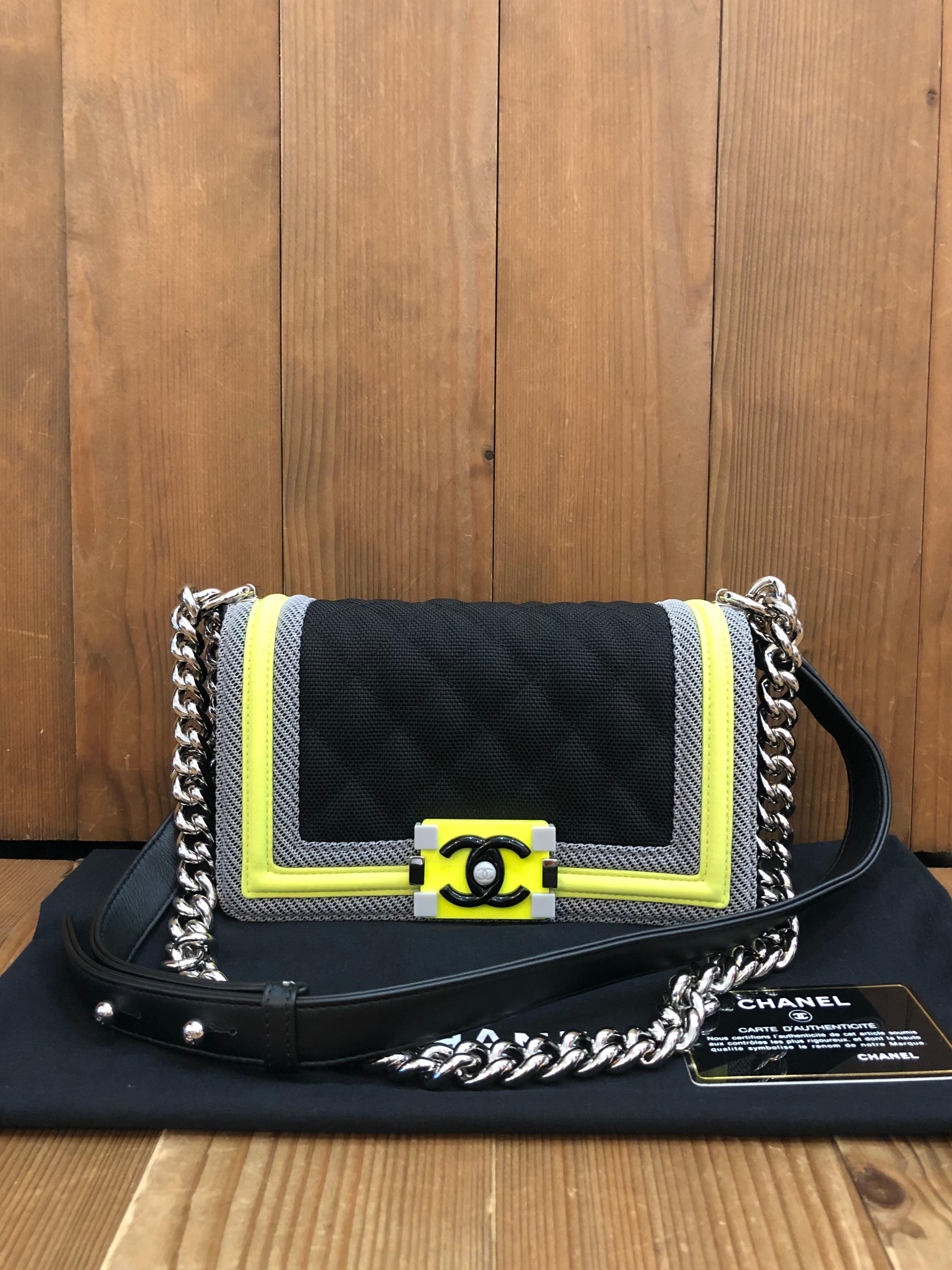 This CHANEL Small Boy bag is crafted of black diamond quilted nylon decorated with green/yellow neon trims. Front flap resin Boy push-lock closure opens to a black textile interior featuring a patch pocket. This Boy features a sturdy silver-toned