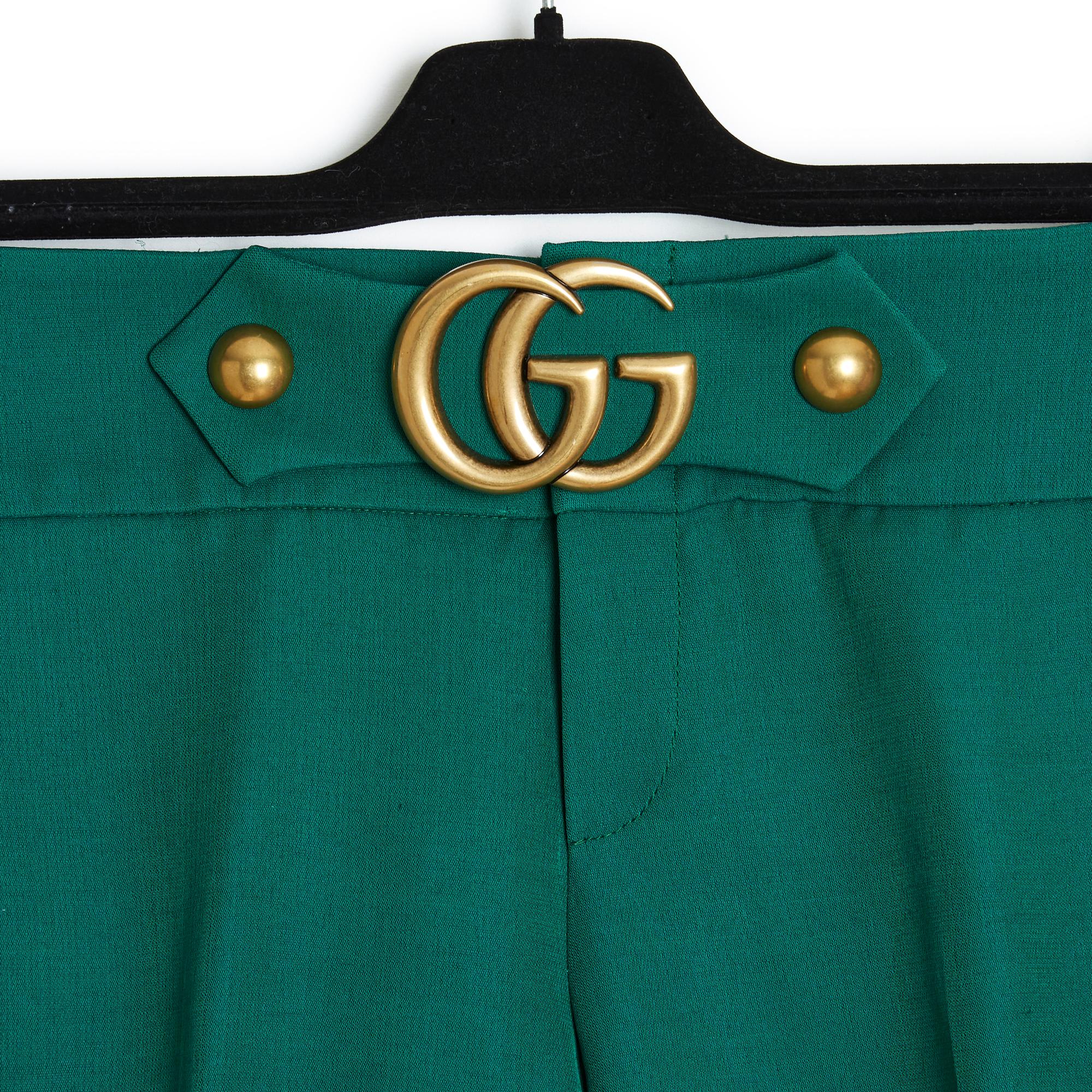Gucci pants year 2016 by Alessandra Michele in wool twill (58%) and green silk, low waist decorated with a GG buckle in gold metal, mid-wide leg at the top and slightly flared at the bottom, ankle length. Size 44IT or 40FR: waist 43 cm, crotch 23