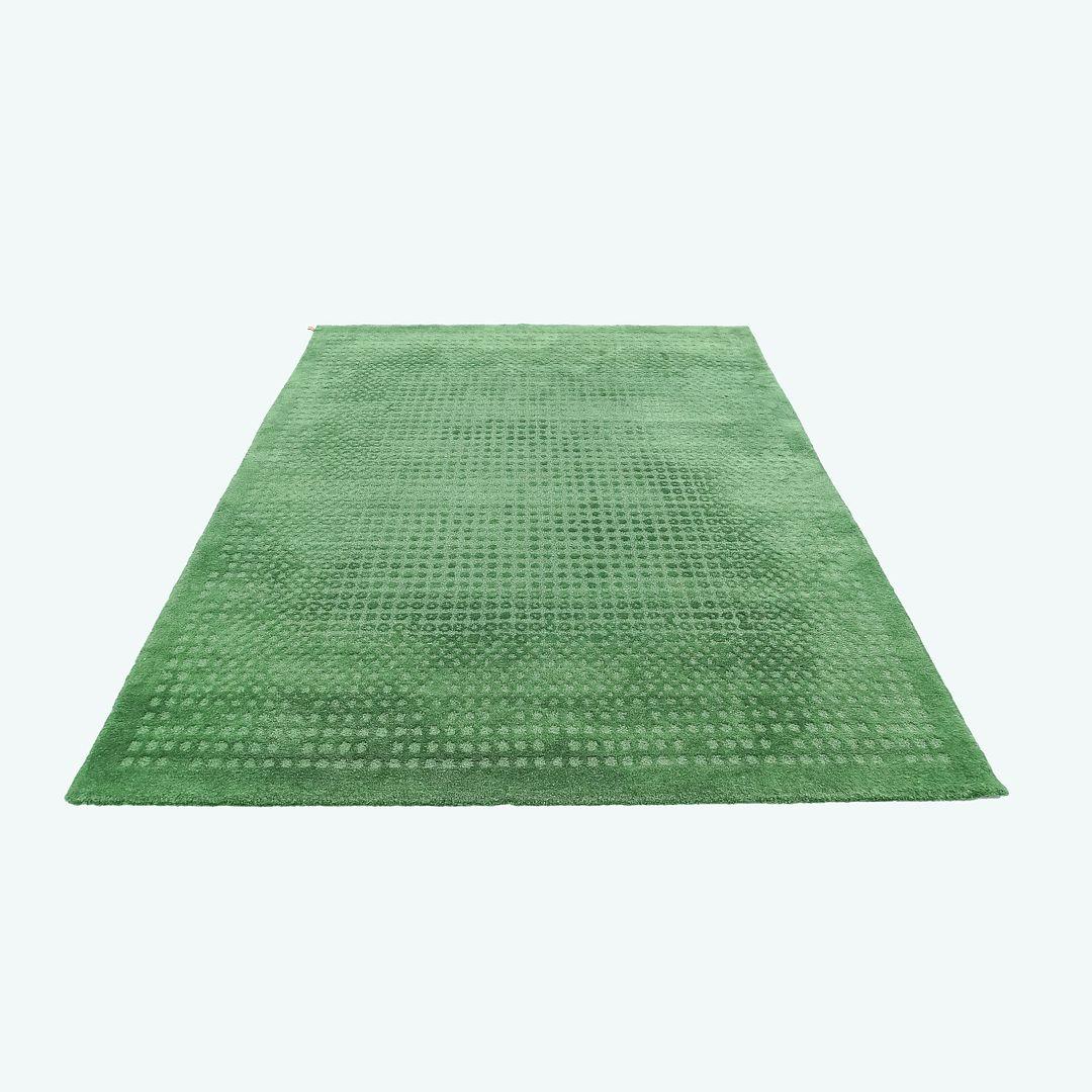 This is a Kasthall area rug woven with pure wool and linen in green. The rug was designed by Maja Johansson Starander and produced by Kasthall in Sweden. It dates to circa 2016 and is guaranteed as authentic. Condition is very good to excellent. See