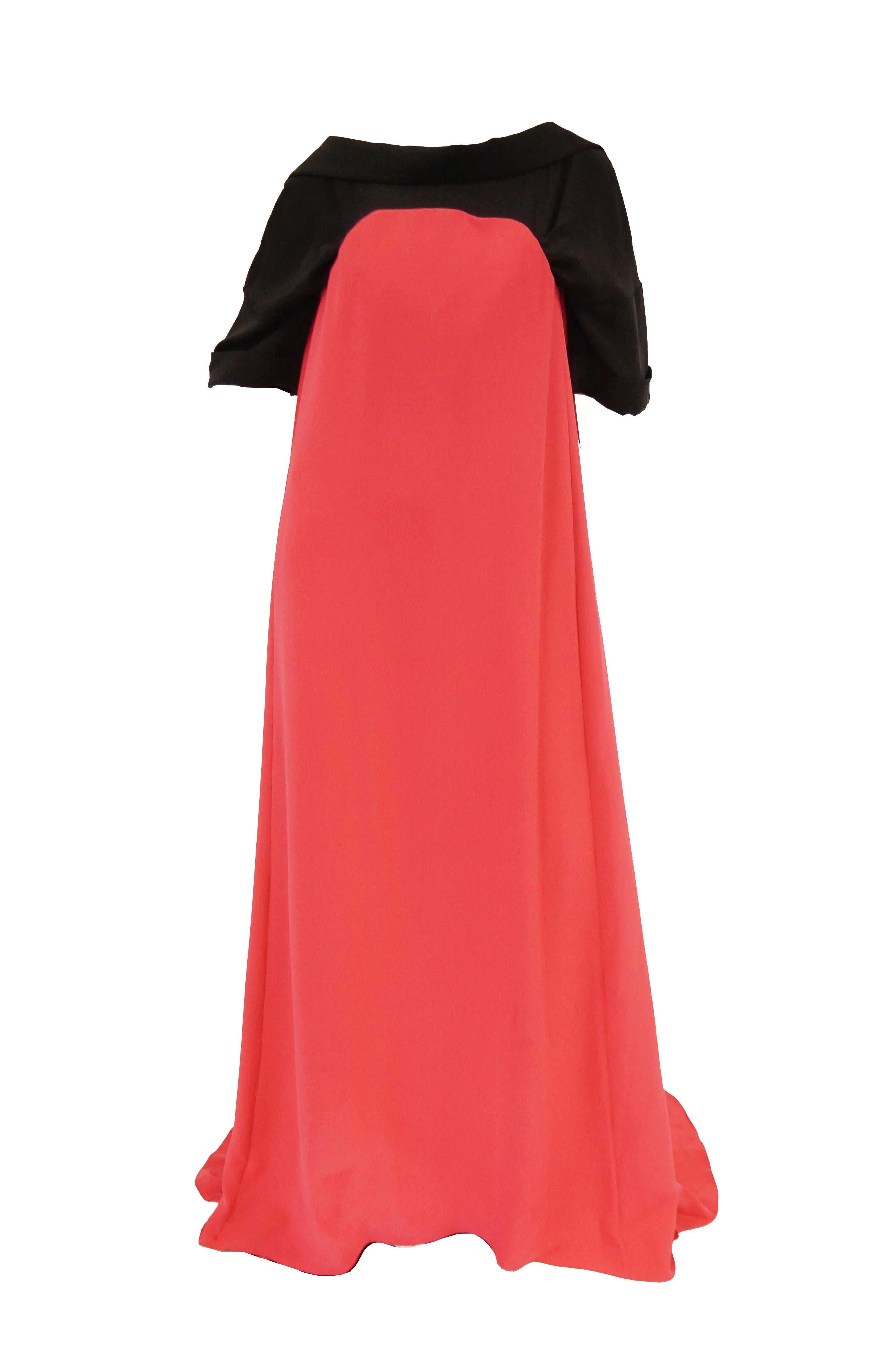 Absolutely incredible magenta pink and black evening dress by Oscar de la Renta. The dramatic dress is composed of two connected parts. The black base dress with a wide bateau neckline and loose sleeves that fall just above the elbow, as well as a