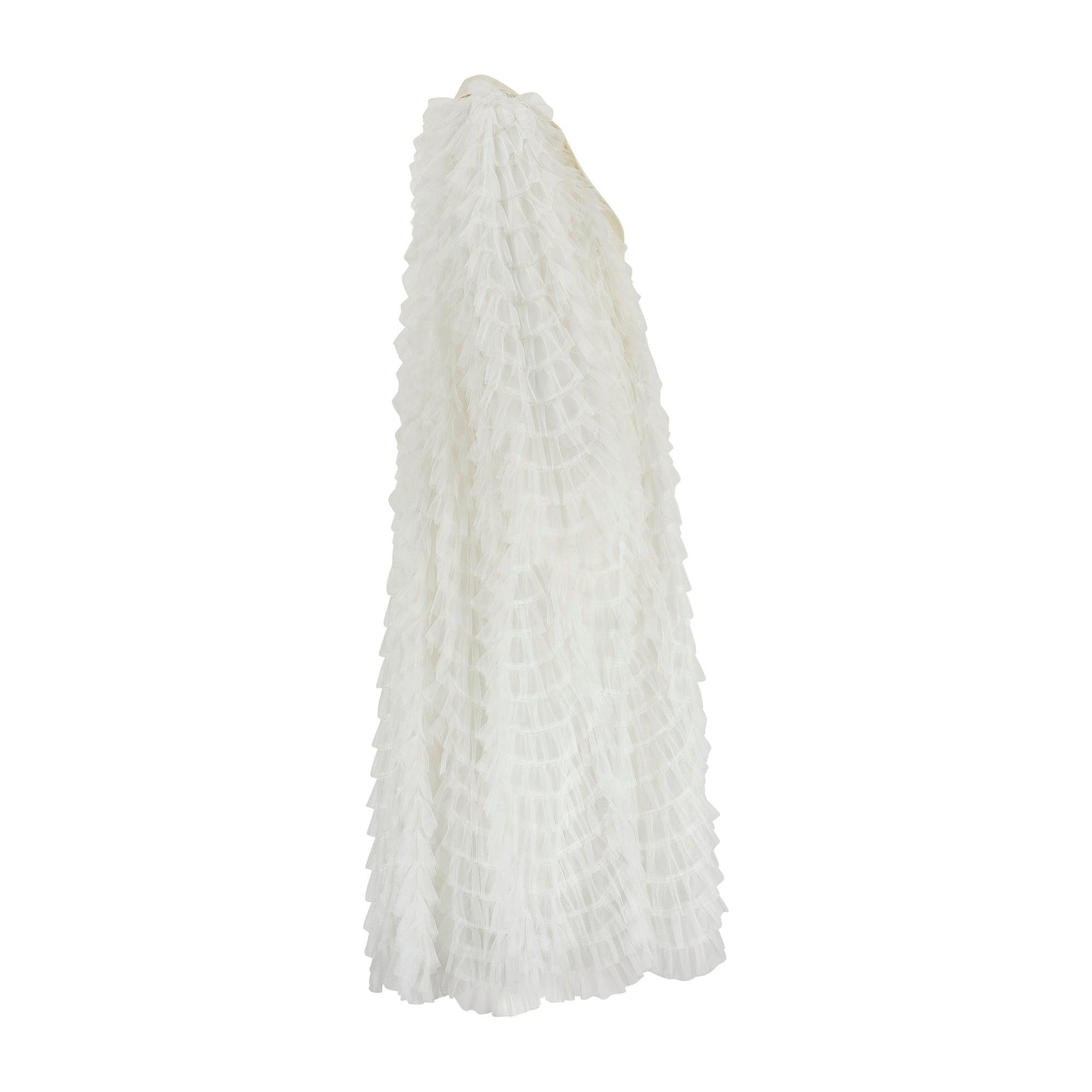 This striking white maxi dress jacket was part of Alessandra Rich’s Fall 2017 ready-to-wear collection (look 13/42). Tailored from dozens of net ruffles layered on top of each other, it has a voluminous, theatrical silhouette that cocoons the body