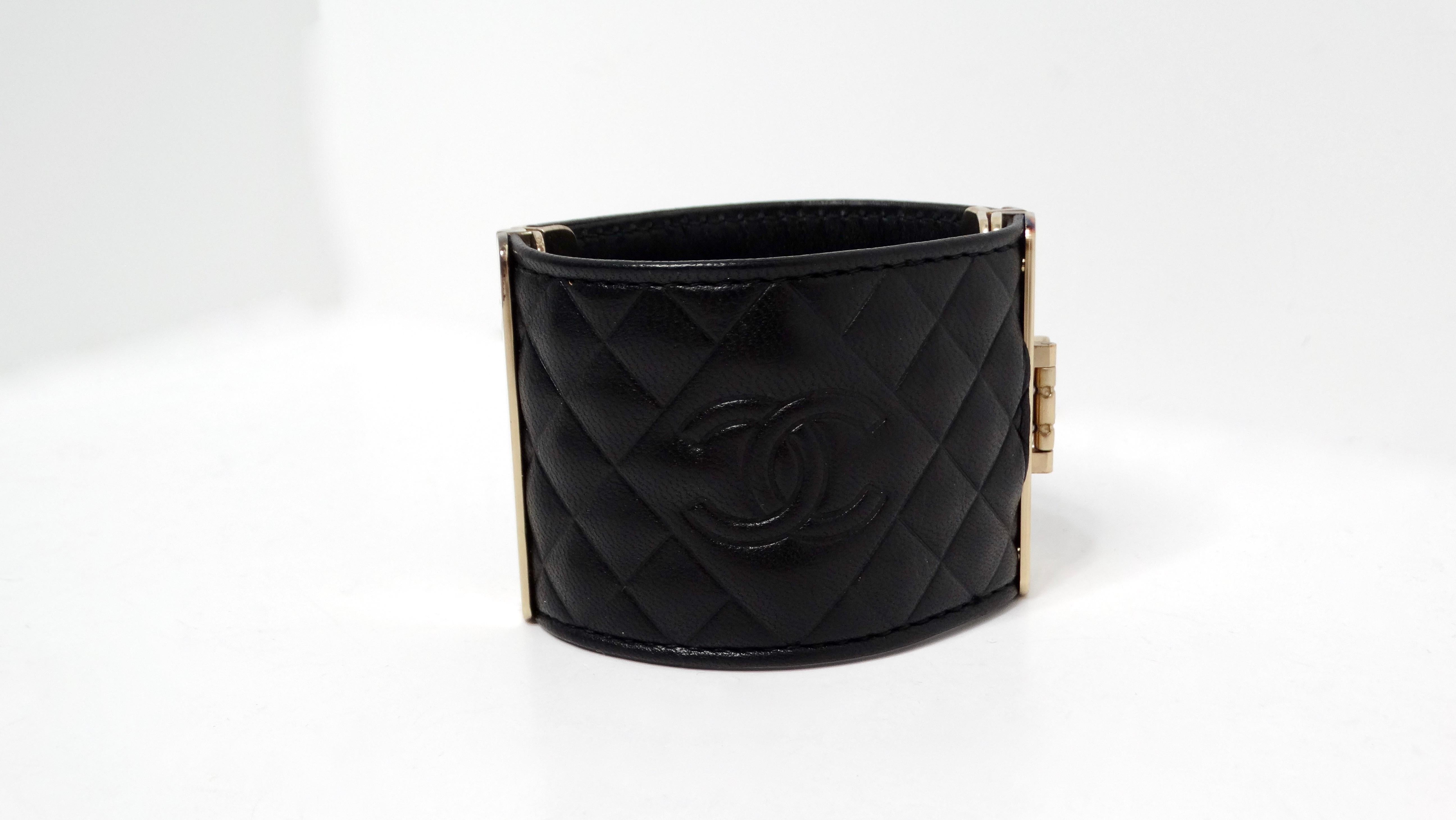 Das 2017 Chanel Black Quilted Calfskin Interlocking CC Embossed Cuff Bracelet ist ein atemberaubendes Accessoire, das Luxus und Raffinesse verkörpert. Dieses Armband aus exquisitem schwarzem Kalbsleder zeigt das ikonische gesteppte Design von Chanel