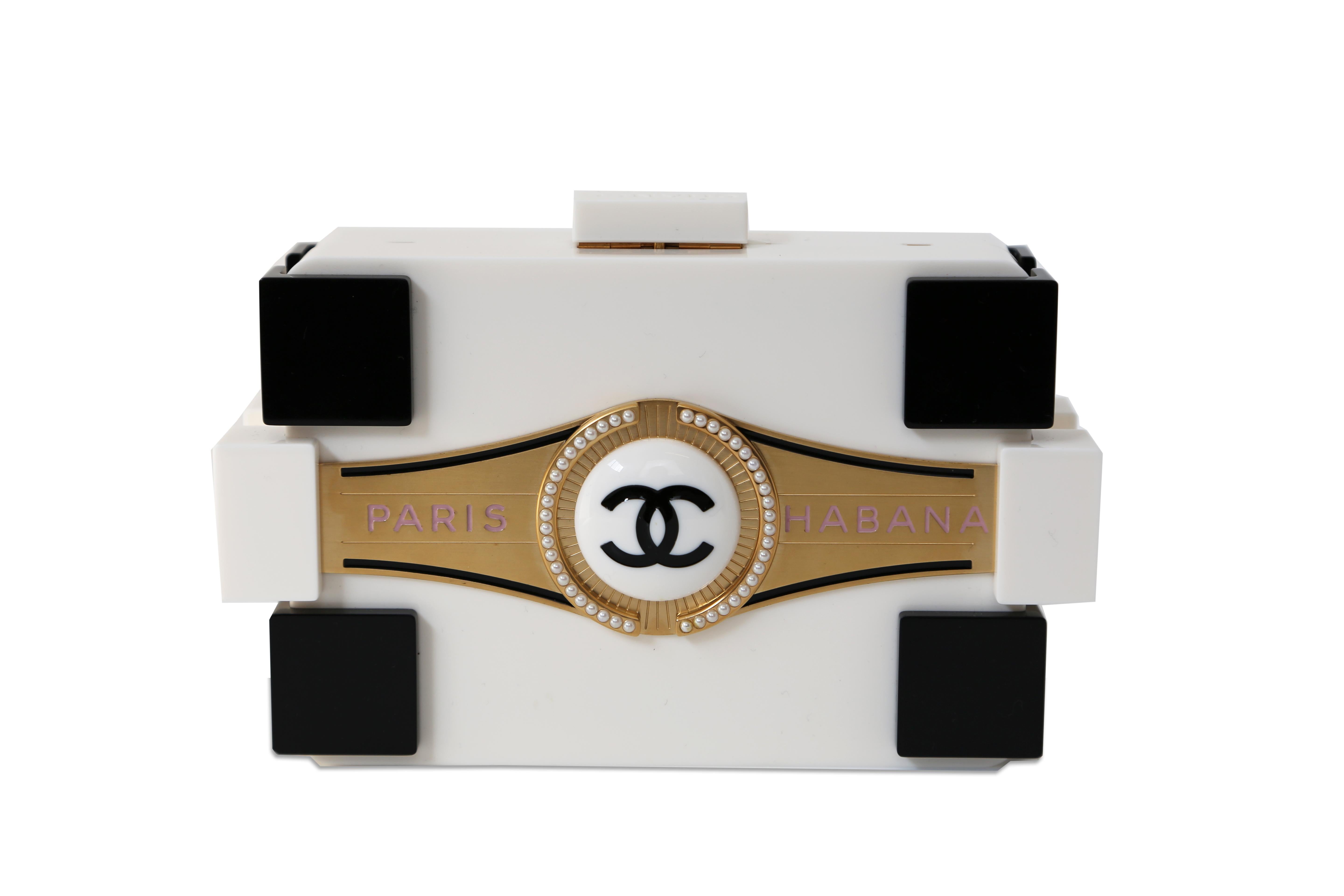 Karl Lagerfeld's lasting impact on fashion shines in this collector's edition clutch from his final runway show. Inspired by Cuba, this rare and hard-to-find bag features a cigar-box design, a lucite Lego Boy Brick shape, and elegant gold and pearl