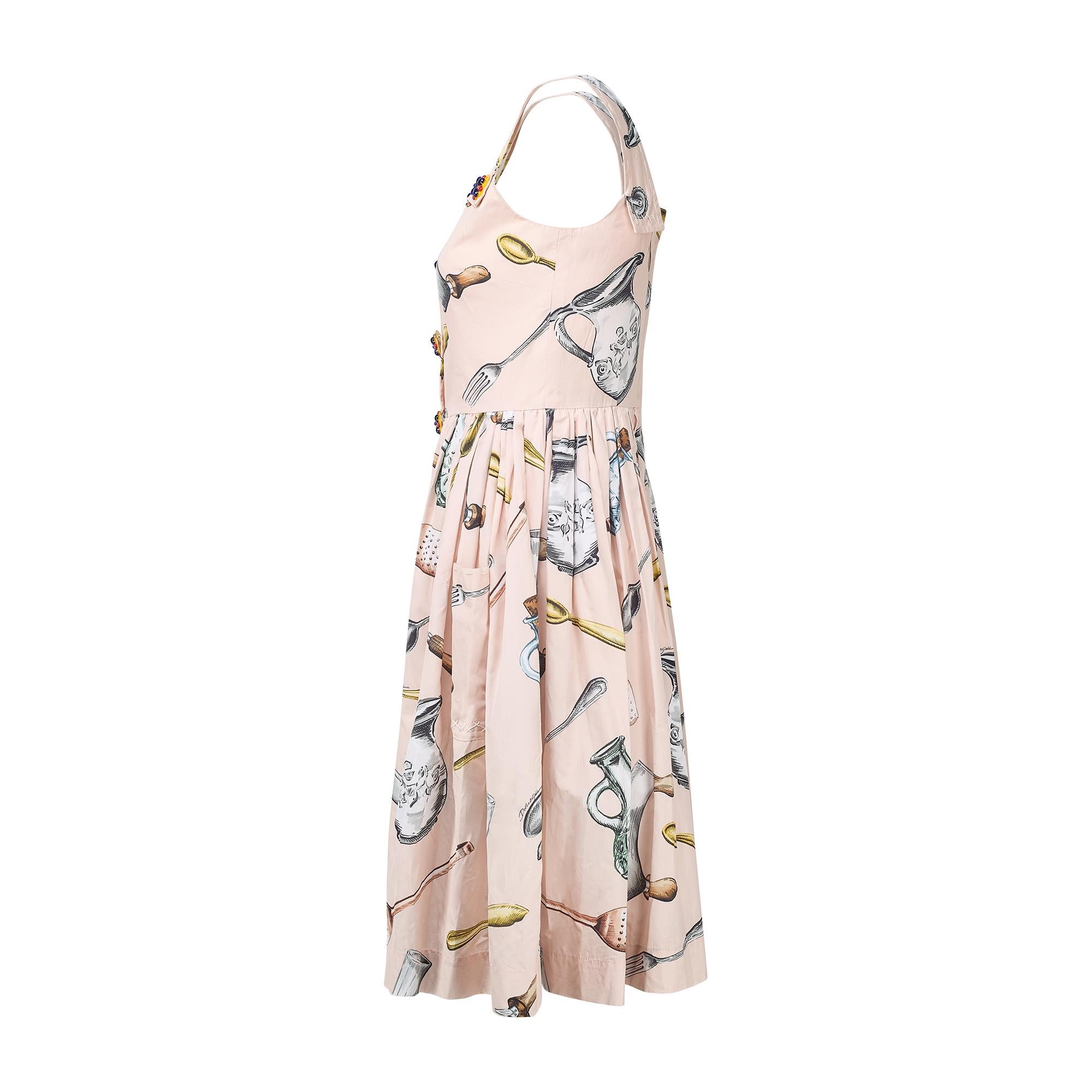 Dieses Kleid war Teil der Frühjahrskollektion 2017 von Dolce & Gabbana und ein Kleid mit demselben Print und Raffia-Detail lief als Look 26/93 über den Laufsteg. Es ist aus blassrosa Baumwolle geschneidert und zeigt einen neuartigen Aufdruck von