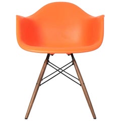 2017 Eames Herman Miller DAW Chaise à coque en plastique orange avec base à chevilles en noyer.