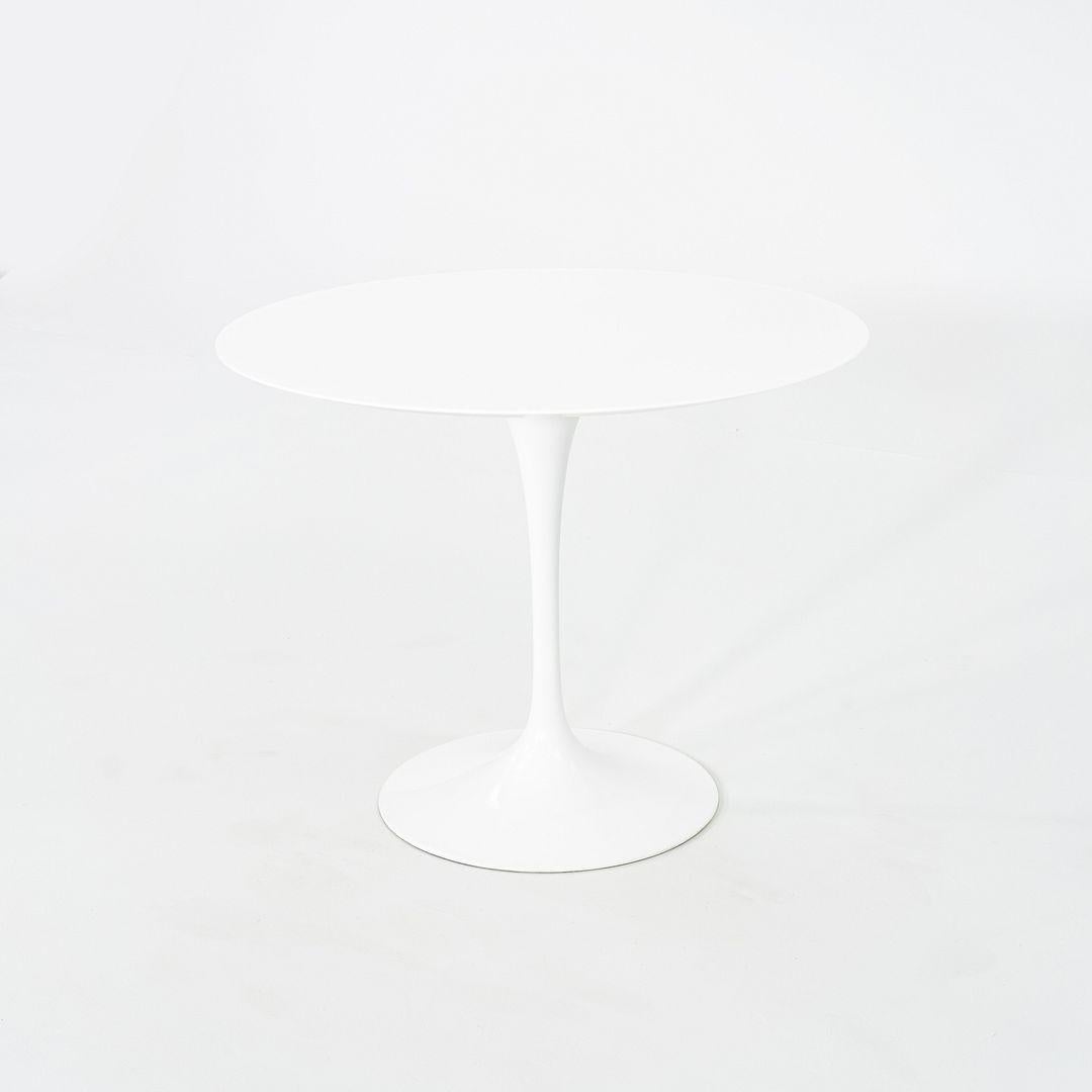 This is a Tulip Pedestal Dining Table, originally designed in 1956 by Eero Saarinen for Knoll. These particular pieces were produced in the USA in 2017. The base is formed of molded cast-aluminum which is coated in a white finish. The vetro bianco