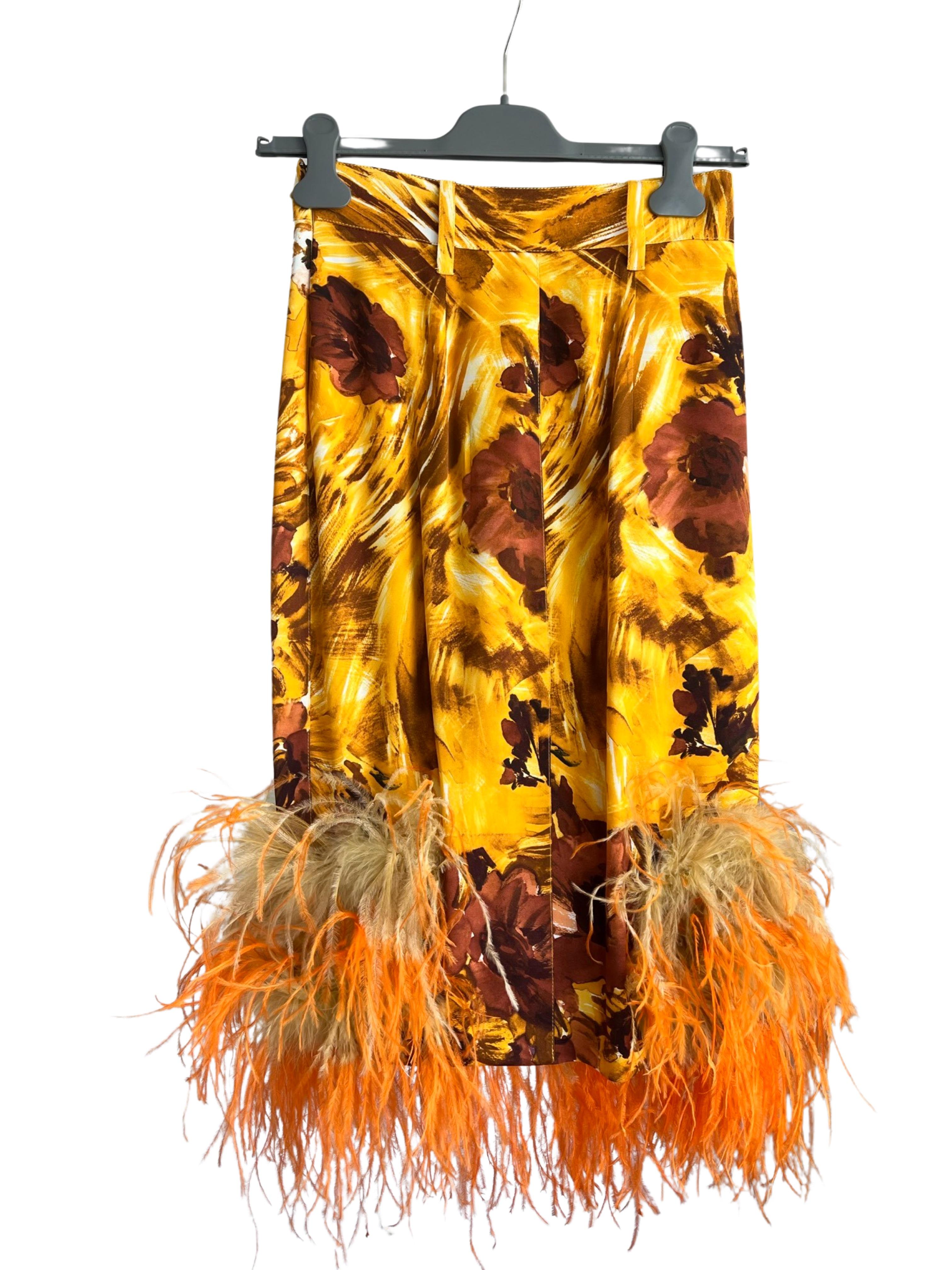 The 2017 Prada runway collection featured a stunning floral silk pencil skirt adorned with vibrant orange and yellow ostrich feathers. This exquisite piece combined the elegance of a classic silhouette with the whimsical beauty of nature-inspired