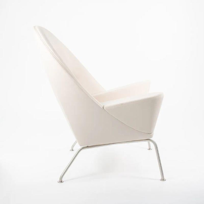 Listed for sale is a Oculus Lounge Chair designed by Hans Wegner, produced by Carl Hansen & Son in Denmark. The chair is made with a stainless steel frame and beige fabric. This chair dates to circa 2018 and is as guaranteed authentic. Condition is