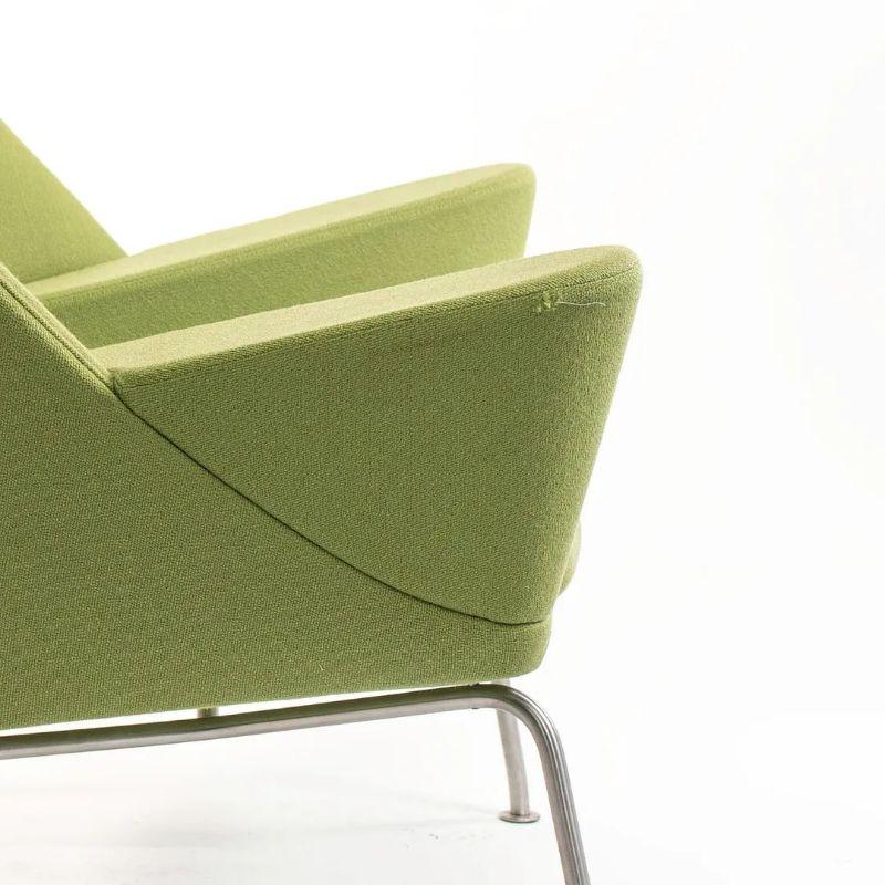 Listed for sale is a Oculus Lounge Chair designed by Hans Wegner, produced by Carl Hansen & Son in Denmark. The chair is made with a stainless steel frame and green fabric. This chair dates to circa 2018 and is guaranteed as authentic. Condition is