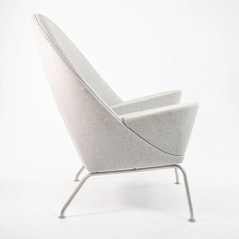 Listed for sale is a Oculus Lounge Chair designed by Hans Wegner, produced by Carl Hansen & Son in Denmark. The chair is made with a stainless steel frame and Divina Melange light gray fabric (DM120). This chair dates to circa 2018 and is guaranteed