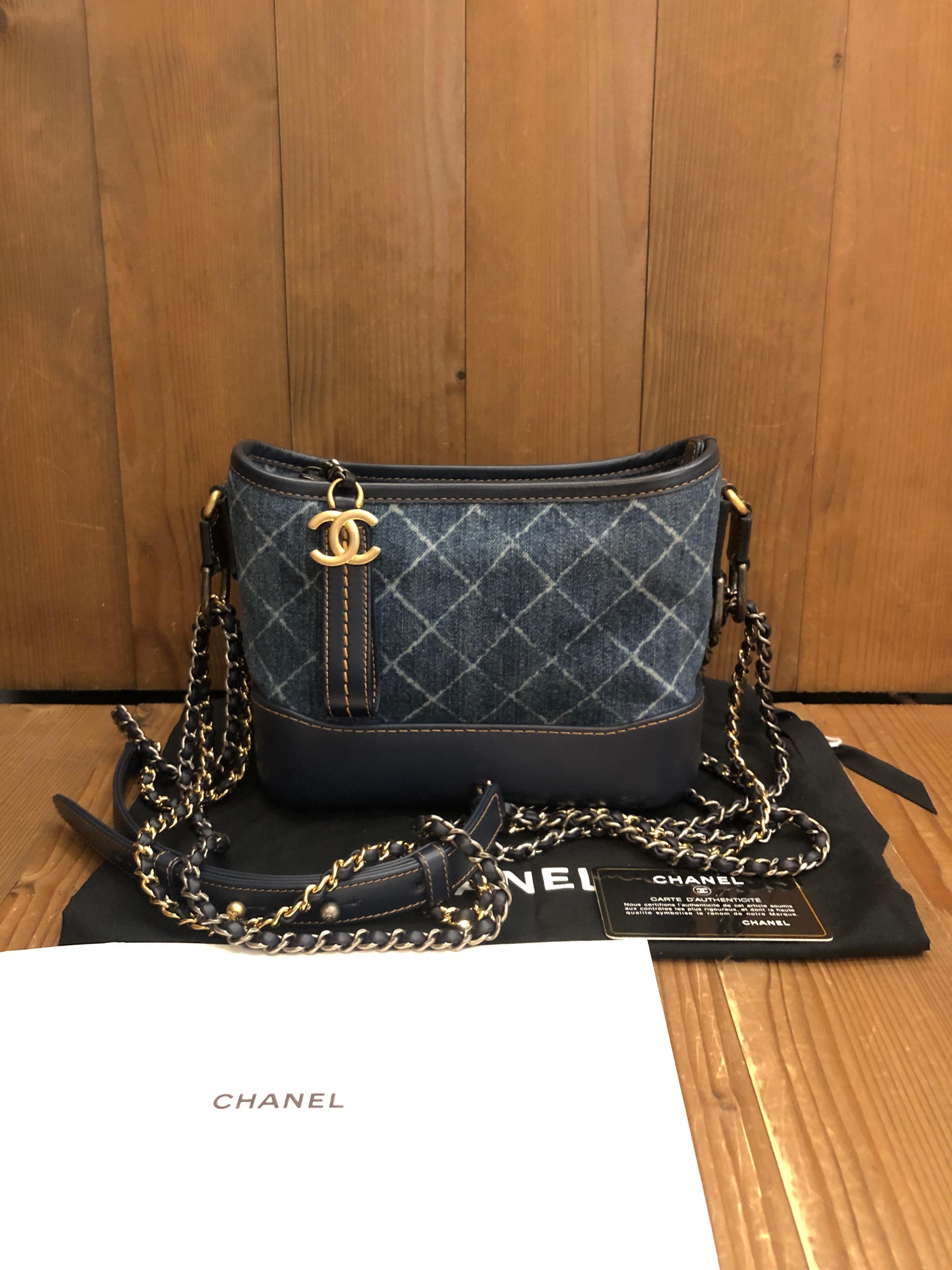 This CHANEL small Gabrielle hobo bag is crafted of blue denim printed in chanel diamond quilted pattern and calfskin leather in blue. Top zipper closure opens to a fabric interior featuring a zippered pocket and a leather strap with clasp. Duel