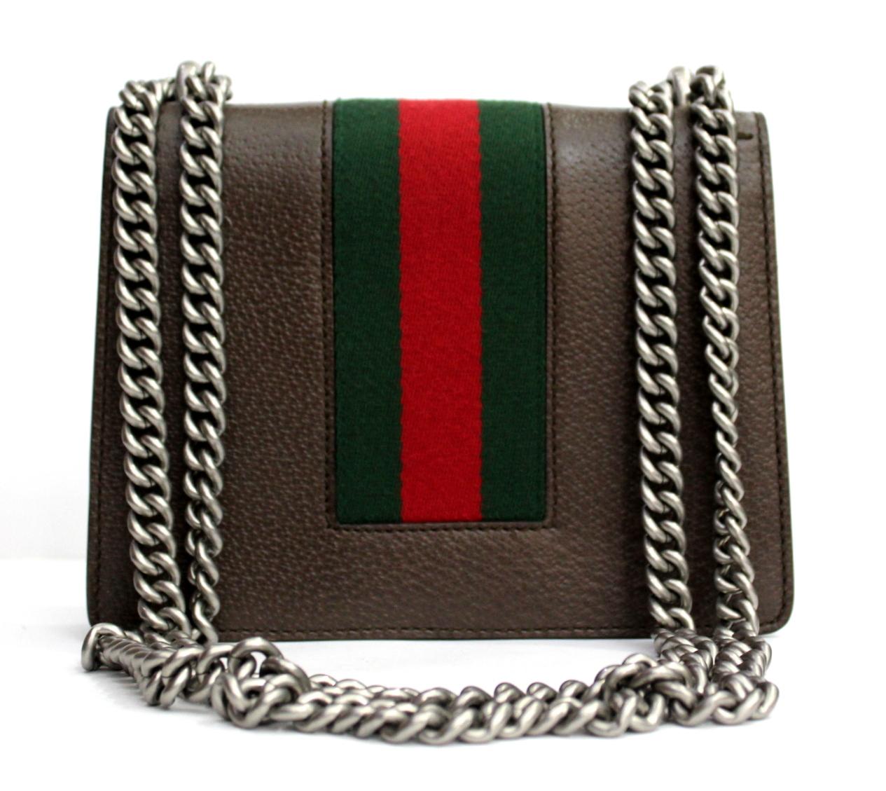 Mini Gucci Dionysus in brown leather with web decoration.
Structured is defined by the buckle with tiger heads.
This model is completed by a sliding chain shoulder strap, which allows the accessory to be worn either as a shoulder bag or as a