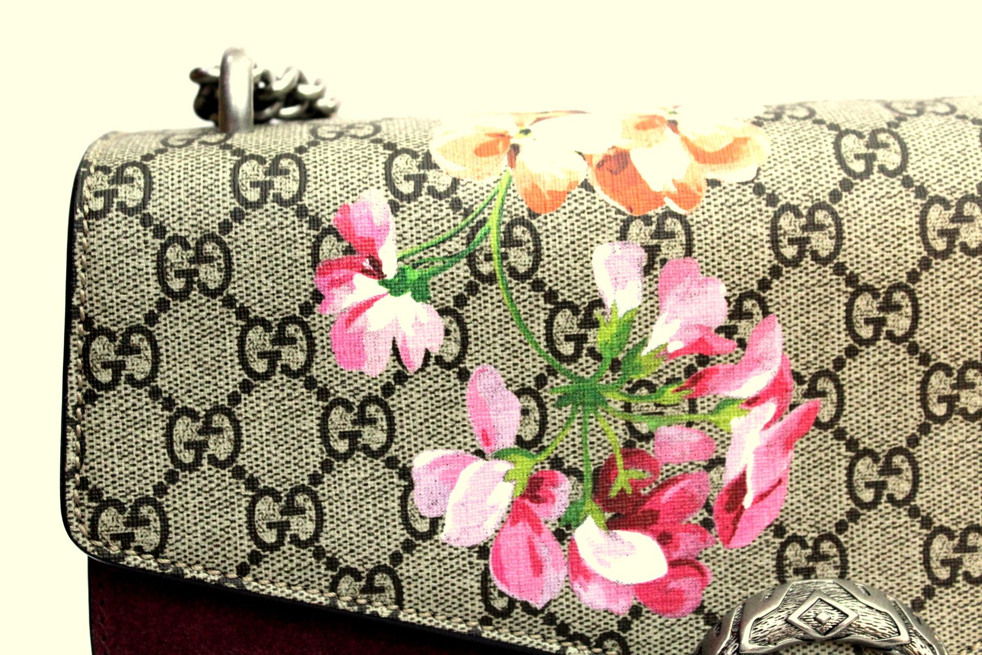 Gucci bag model Dionysus, made of GG Supreme fabric, with Blooms print and antique pink suede detail. Antique silver-colored finishes. Thanks to the sliding chain shoulder strap to be worn in several ways, it can be worn as a shoulder bag or