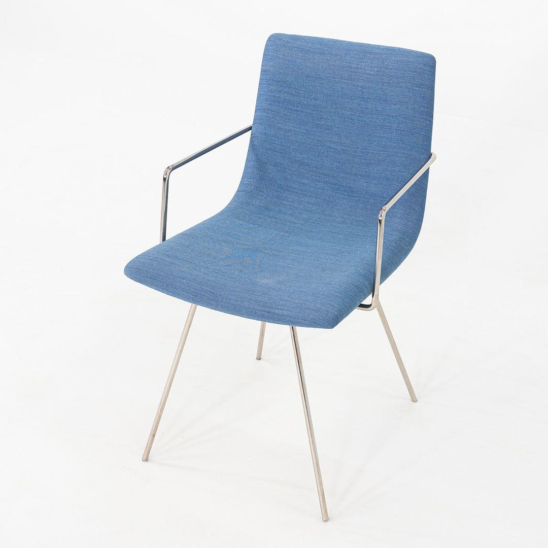 Il s'agit d'une paire de chaises à accoudoirs Capra, conçues à l'origine par Lee Pasteris pour Martin Brattrud. Ces exemplaires ont été produits aux États-Unis en 2018. Chaque chaise présente une silhouette légèrement incurvée, revêtue de Maharam
