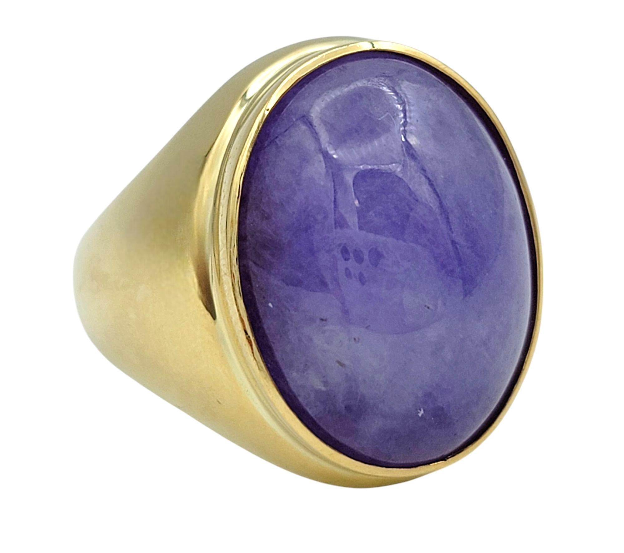 Ring Size: 10 

A stunning fusion of color and craftsmanship, this exquisite ring features an oval cabochon-cut jadeite in a rich shade of purple. The smooth, polished surface of the jade enhances its soft translucency, creating an alluring glow