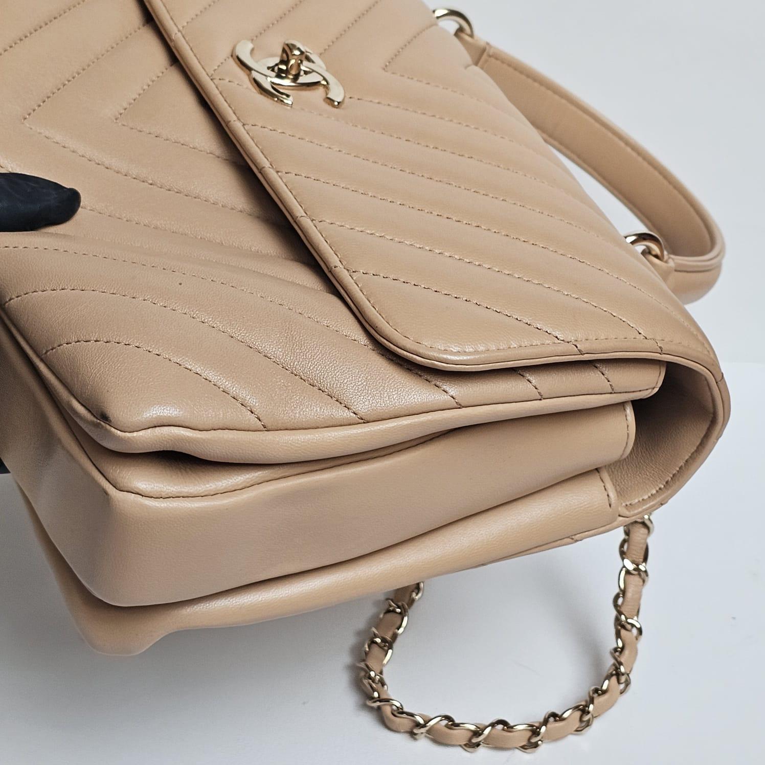 Chanel trendy in medium beige chevron lambskin with gold hardware. Easy to wear for everyday bag. Neutral color. Minor creasing and scuffing on the leather surface. Comes with its holo, card, dust bag. Series #26.
