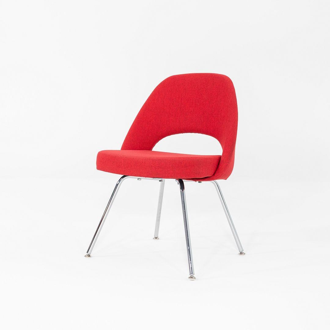 This is a Saarinen Executive Side Chair, originally designed by Eero Saarinen in 1957. This particular example was produced by Knoll in the USA in 2019. The chair features an upholstered seats in red fabric, and the legs are formed of chromed