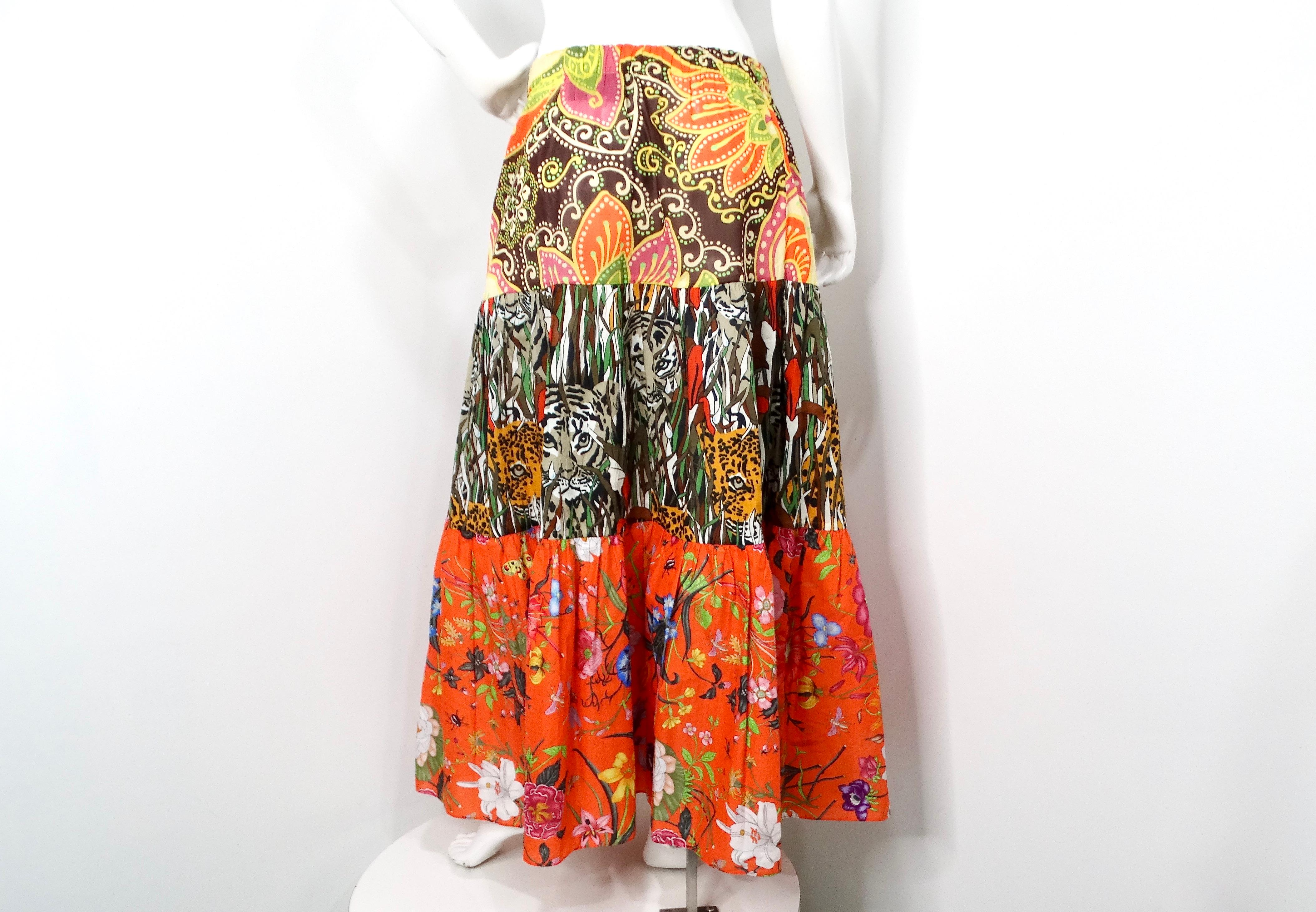 La gonna midi in cotone con stampa multicolore arancione &New India 2019 di Gucci è un pezzo vibrante che incarna lo spirito della moda eclettica. Caratterizzata da uno splendido motivo a blocchi con gatti della giungla e lussureggianti stampe