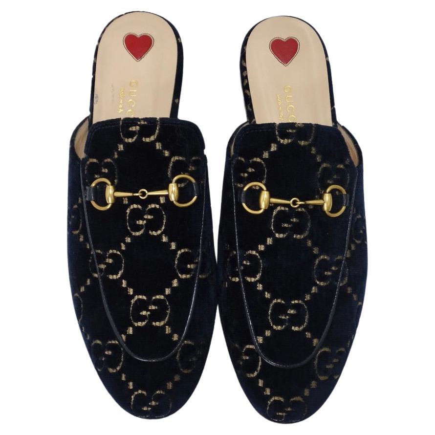 Gucci presents an elevated take on their classic loafer with these stunning blue velvet slip on mules circa 2019. A monogrammed navy blue velvet is complimented by a gold hardware horsebit motif in the center. These are the perfect versatile dress