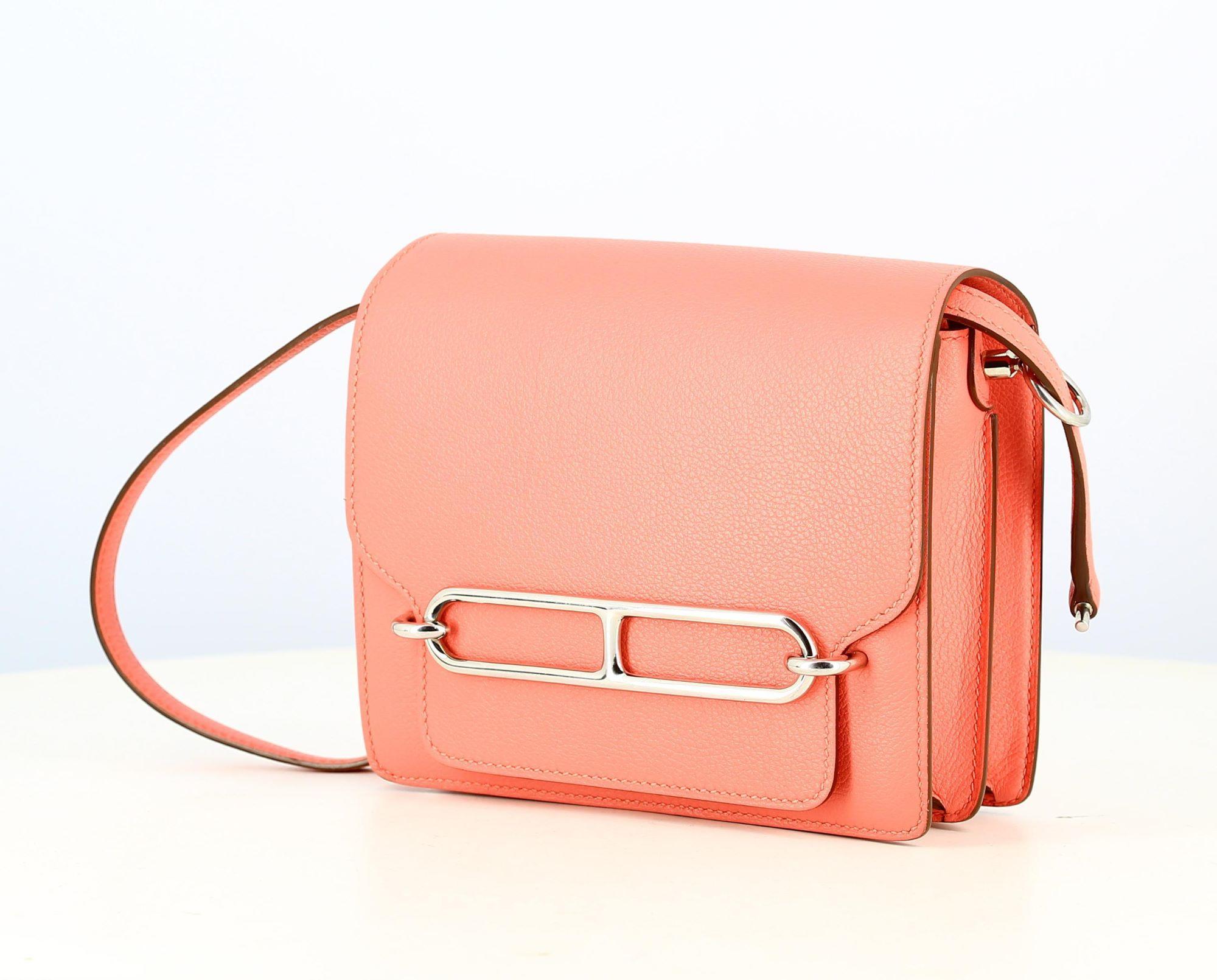 2019 Hermes Pink Mini Roulis
- Good condition, shows slight wear and tear over time - Hermes pink shoulder bag, palladium with H on the front, opens like an envelope, long pink leather shoulder strap. Small pocket on the back of the bag
- The inside