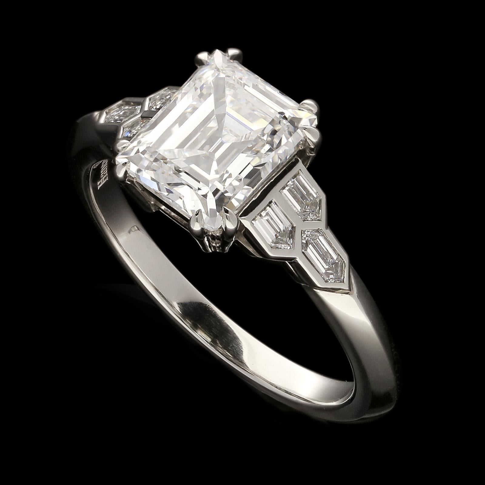 Description
An elegant step cut diamond ring by Hancocks, set to the centre with a beautiful vintage Carré cut diamond weighing 2.01cts and of D colour and VVS1 clarity in double corner claws to a simple double bar gallery between shoulders set with
