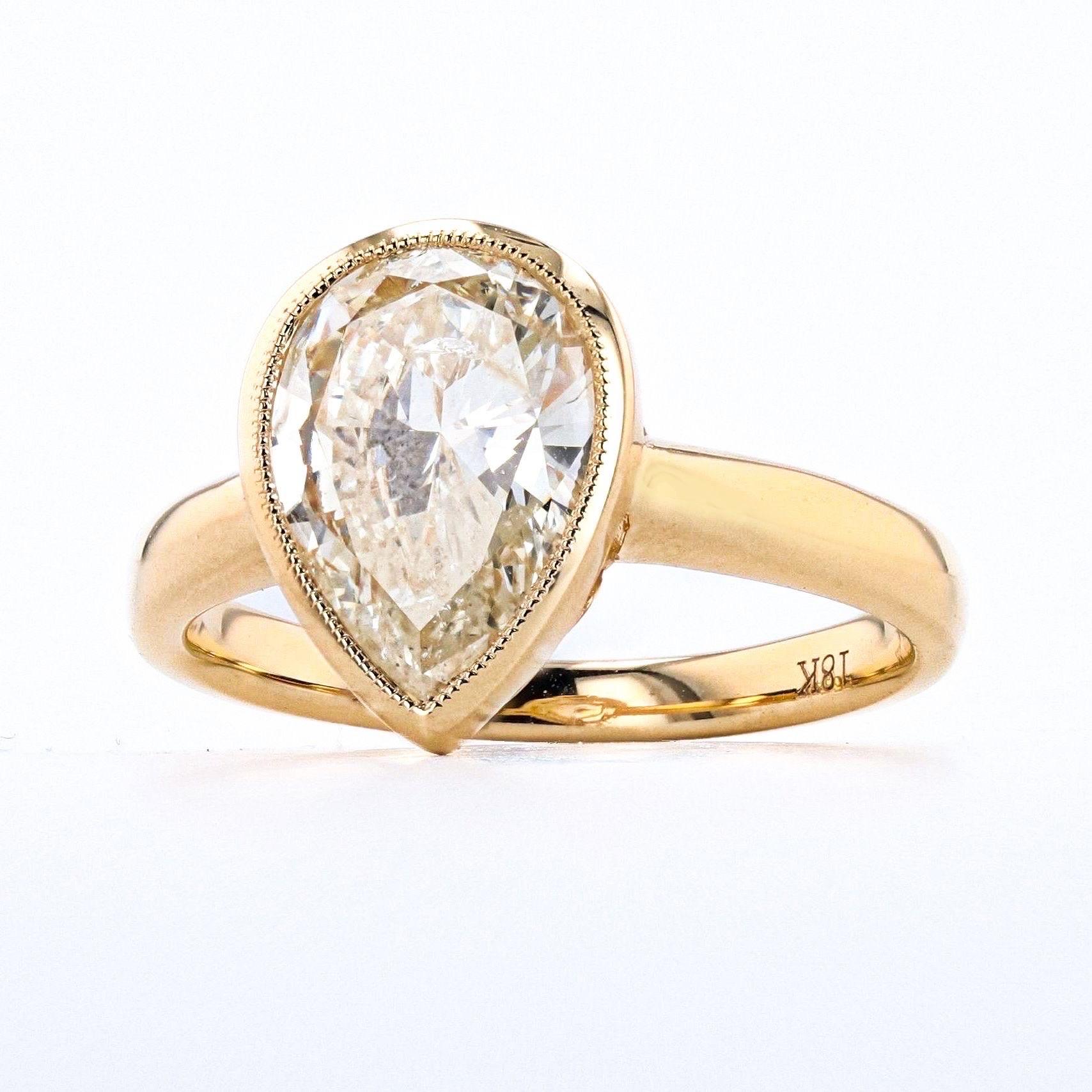 Ti presentiamo un magnifico anello con diamante a forma di pera da 2,2 carati, splendidamente incastonato in un ricco oro giallo. Lo squisito design è caratterizzato da dettagli milligrain unici che aggiungono un tocco di eleganza di ispirazione