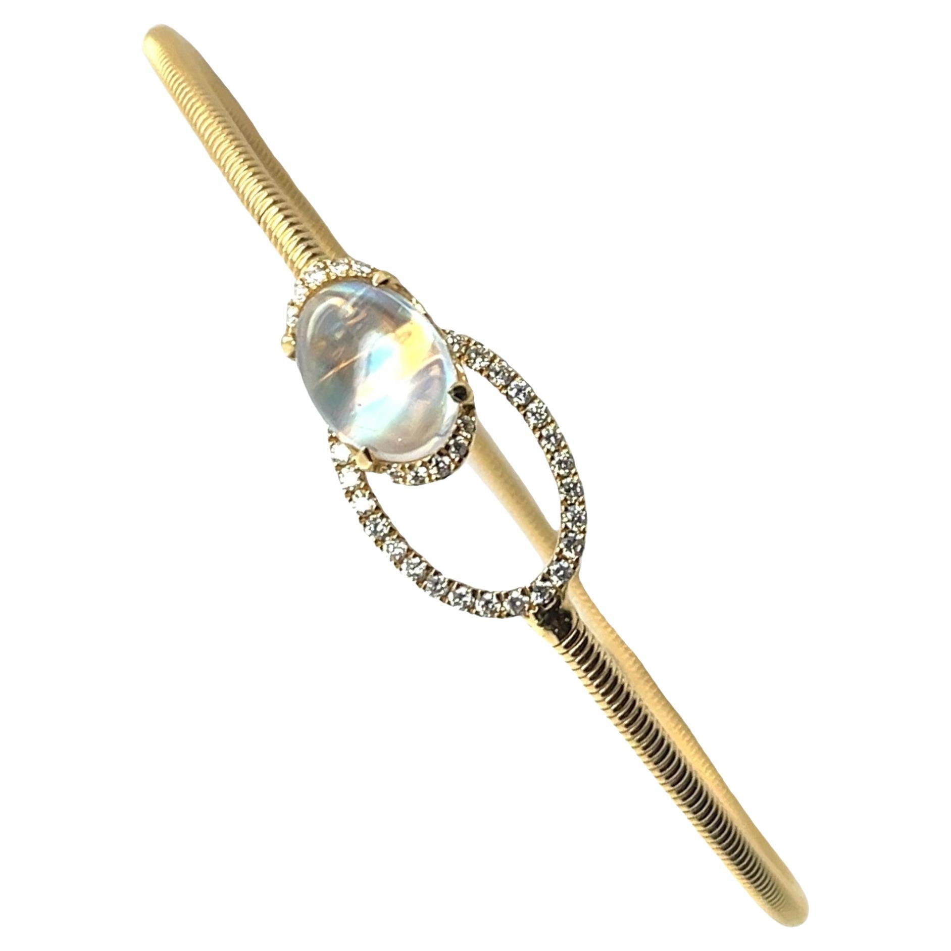 This clever bangle bracelet features a fine 2.02 carat moonstone cabochon with beautiful adularescence set with diamonds in a unique and fun design! Perched in an 18k yellow gold setting and adorned with sparkling white diamonds, the moonstone slips