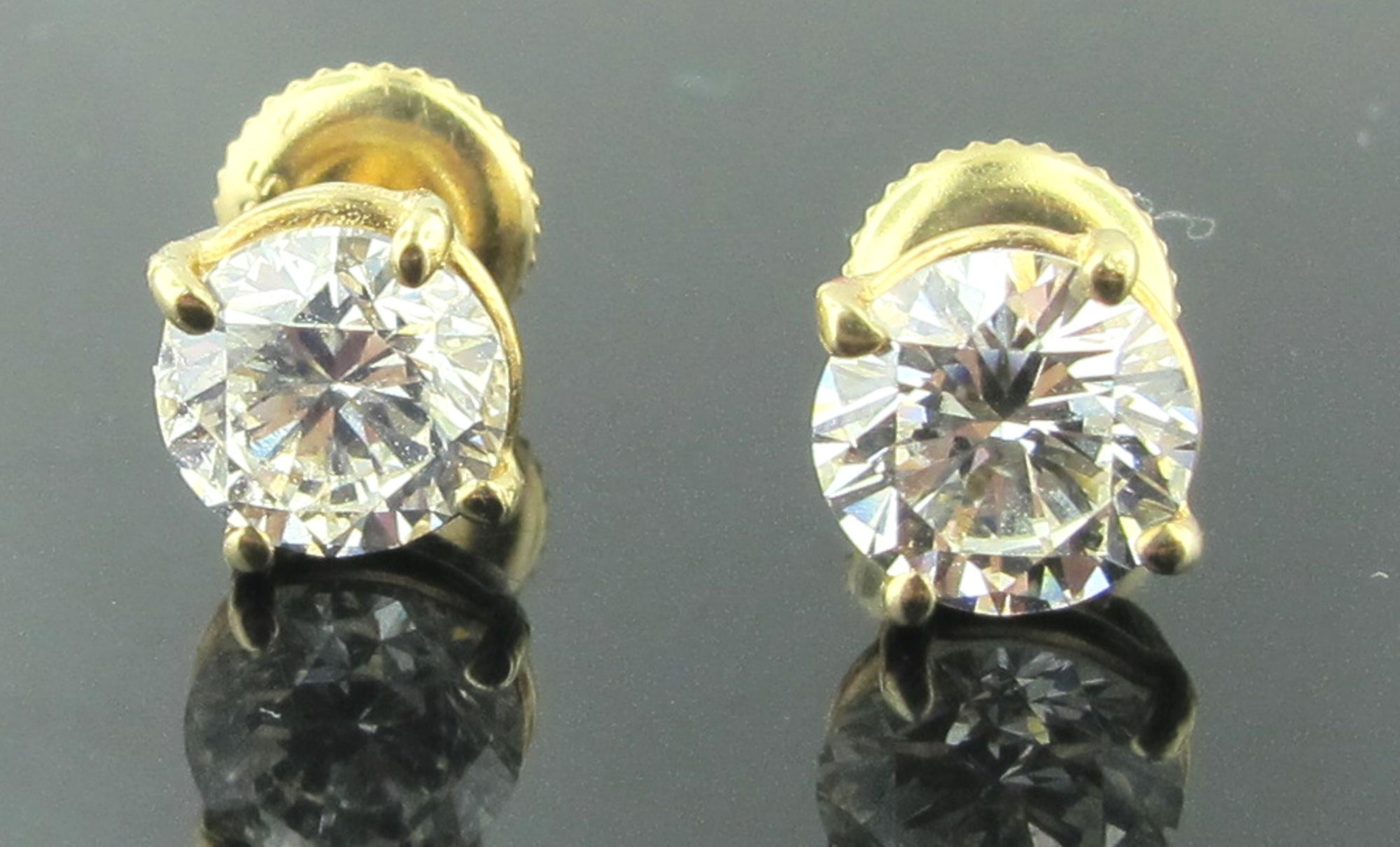 Set in 14 karat yellow gold are two round brilliant cut diamonds with a total weight of 2.02 carats.  Color is G.  Clarity is VS-1. Set with screw backs. 