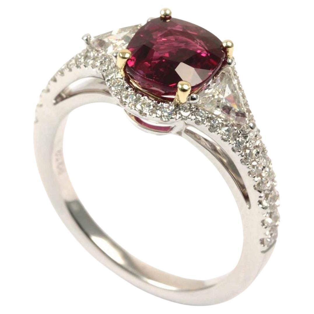Set with an cushion-shaped ruby weighing 2.02 carats, flanked on either side by triangular shaped diamonds weighting 0.42 ct, surrounded by multiple round diamonds totaling 0.42 ct and mounted in 18k white gold, ring size 6½

Accompanied from the