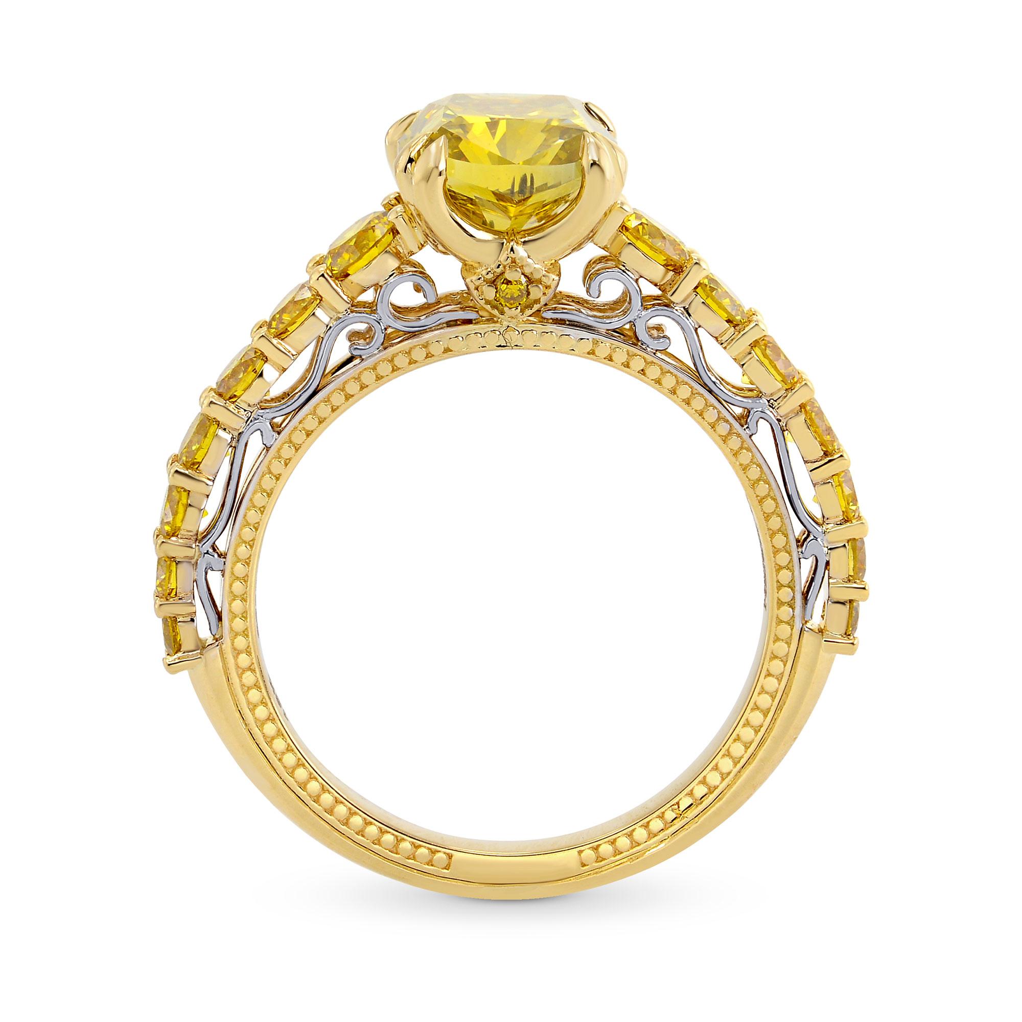 Un eccezionale anello con pietra laterale, con un diamante a cuscino di colore giallo bruno intenso, incastonato in una montatura a griffe con il diamante centrale del peso di 2,02 carati e certificato da GIA. La galleria inferiore presenta un