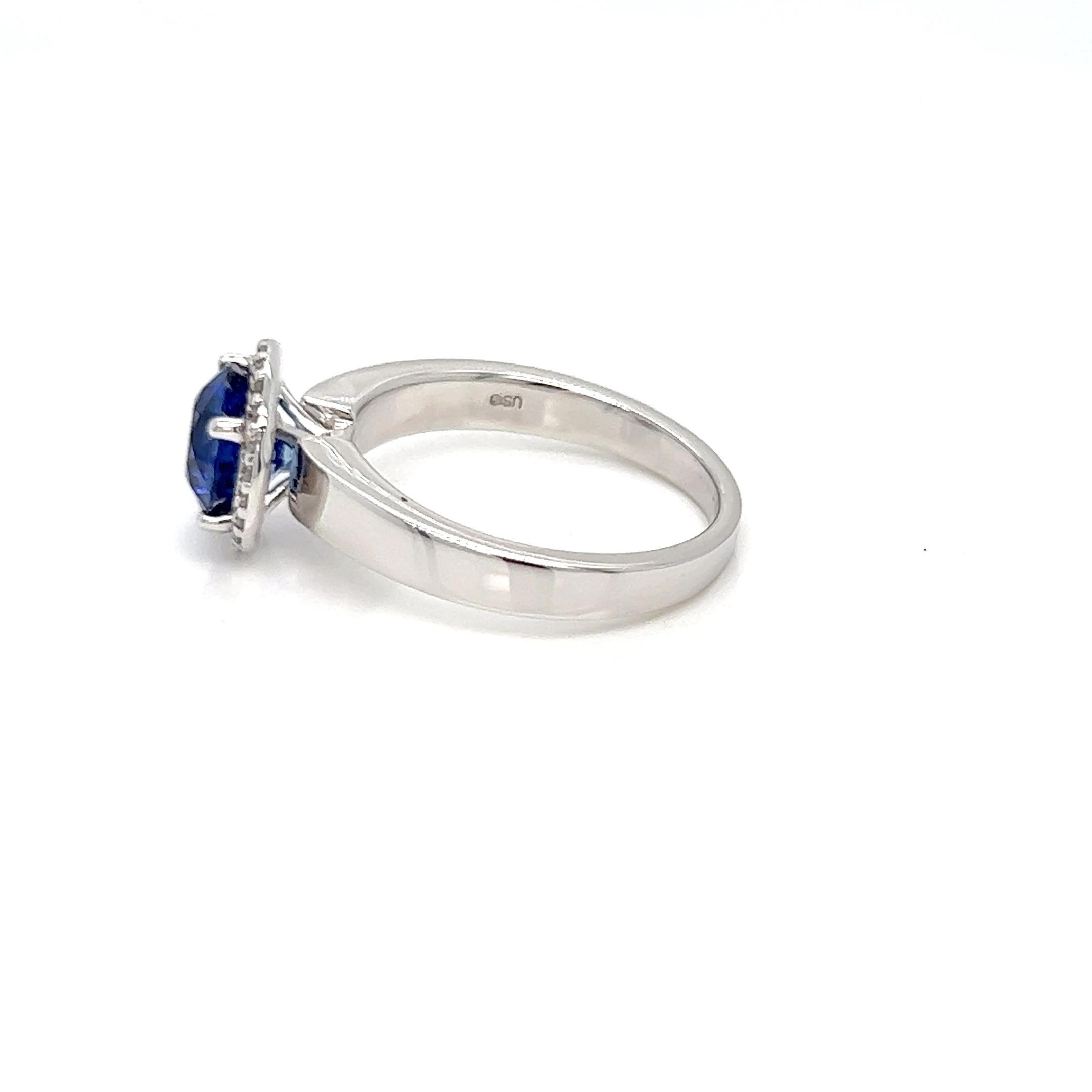 Dieser spektakuläre Saphir-Solitär-Halo-Ring mit Diamanten besteht aus einem 1,91 Karat schweren Saphir aus Sri Lanka, der für seinen leuchtend blauen Farbton bekannt ist, umgeben von natürlichen Diamanten von 0,11 Karat. Die perfekte Harmonie von